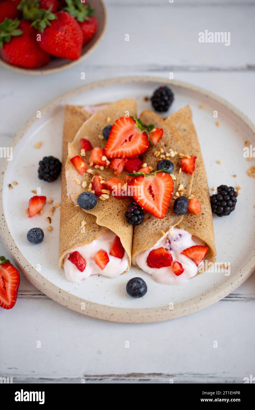Crepes di grano saraceno con panna e frutti di bosco Foto Stock