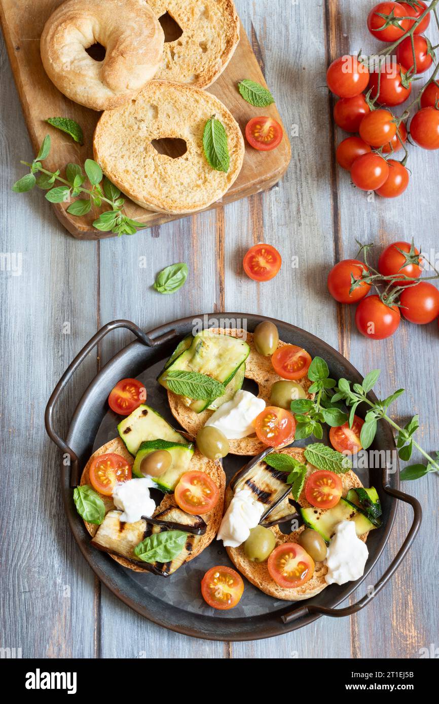 Friselle di grano duro (pane italiano meridionale) con melanzane, zucchine e pomodori Foto Stock