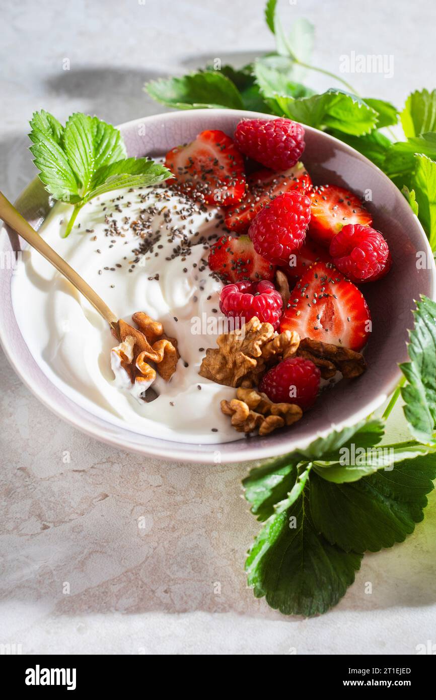 Yogurt semplice con frutti di bosco e noci Foto Stock