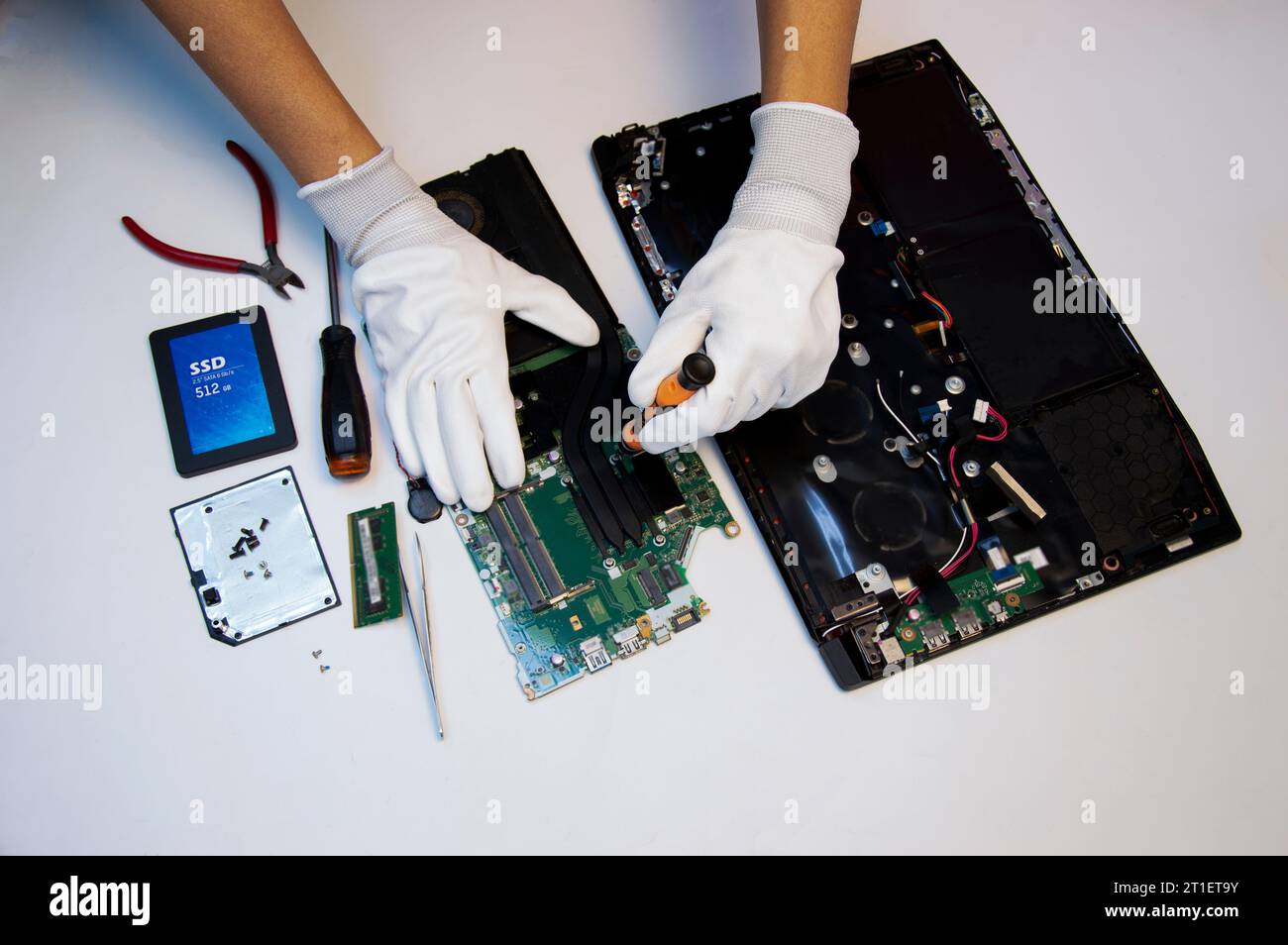 Vista dall'alto. Tecnico che ripara il notebook, ripara la scheda madre e il circuito. Foto Stock