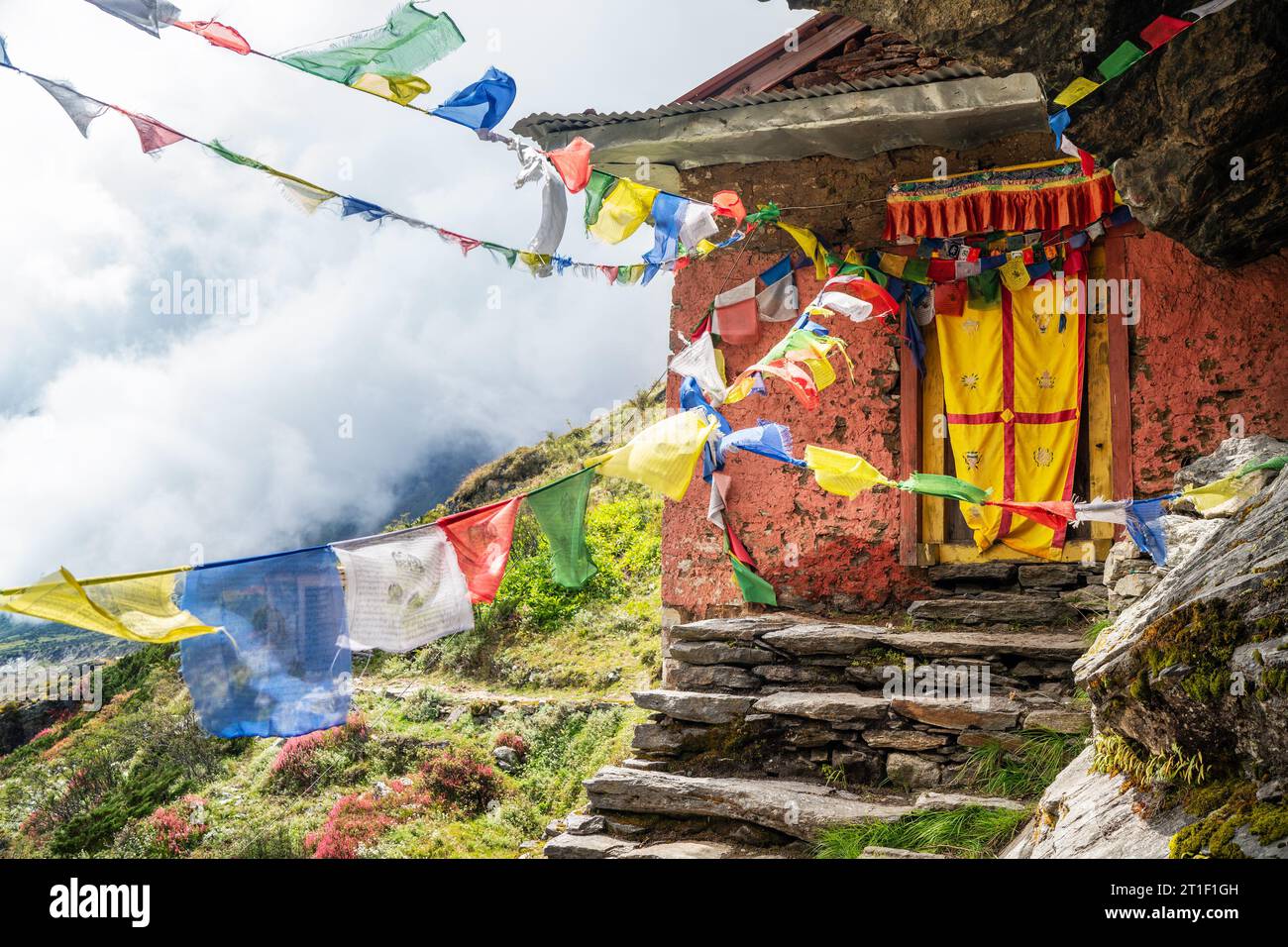 Piccolo monastero buddista decorato con bandiere di preghiera tibetane multicolori con mantra sulla via Kothe-Thangnak che sale sulla cima Mera a Makalu Barun Na Foto Stock