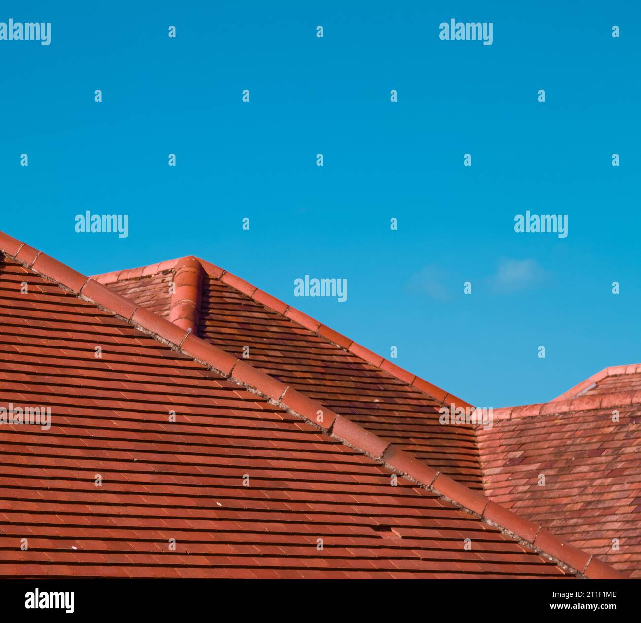 Tetti piastrellati in terracotta adagiati su Un cielo blu che imita le montagne in Un paesaggio, Regno Unito Foto Stock