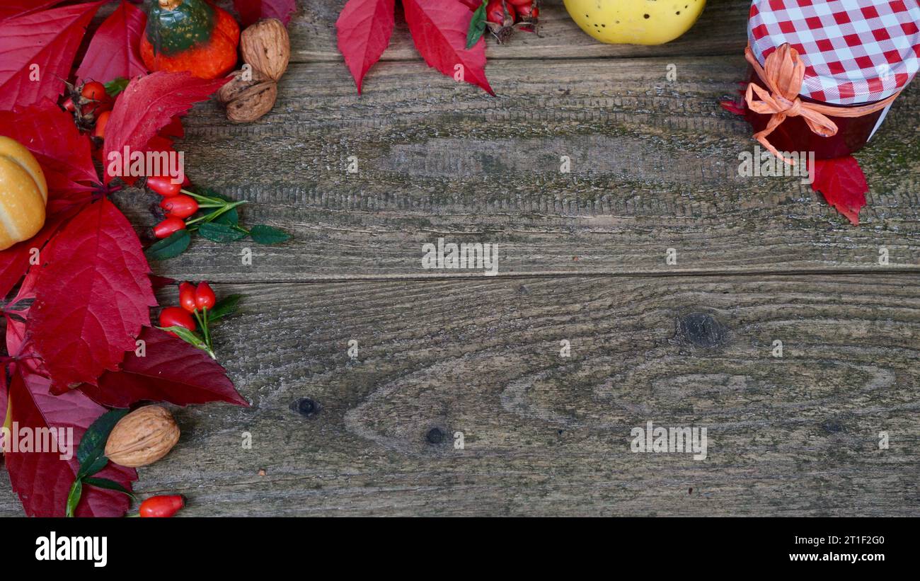 Decorazione autunnale con foglie rosse di vite selvatica, mucche, barattolo di gelatina, cotogna su legno stagionato. Spazio per il testo. Foto Stock