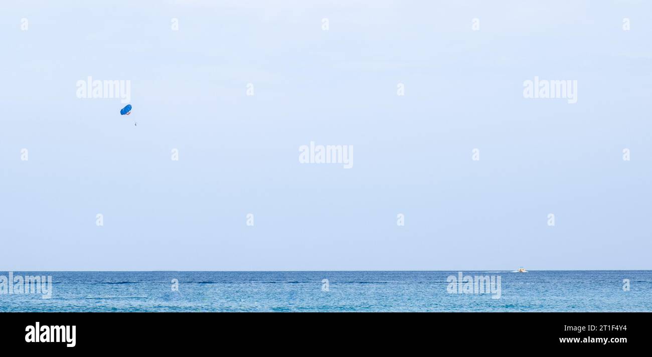 Turisti che fanno paracadutismo in mare. Vacanze estive di intrattenimento, sport estremi all'aperto Foto Stock