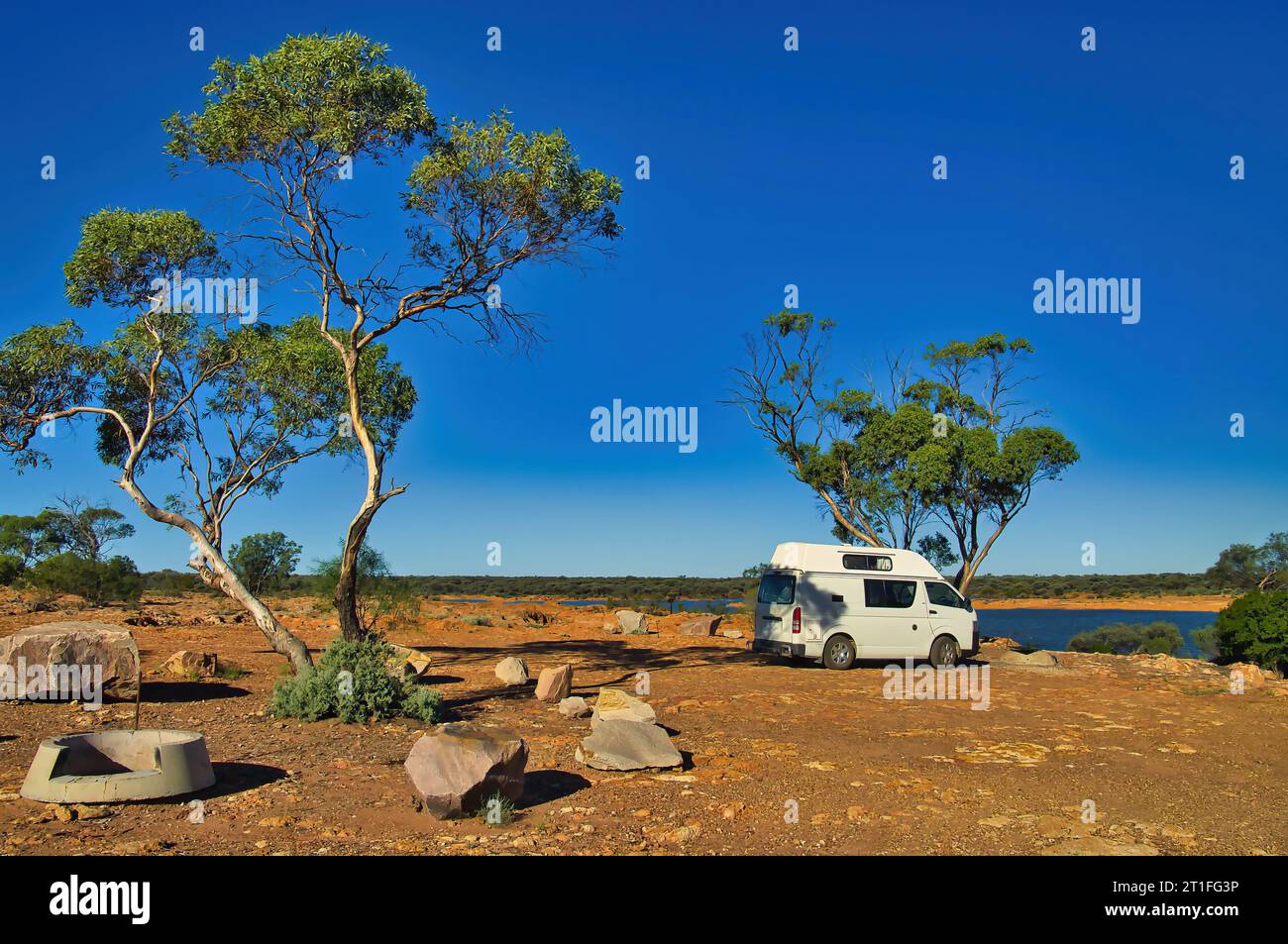 Piccolo veicolo ricreativo parcheggiato sulla riva di un piccolo lago nell'entroterra rosso australiano. Riserva naturale della diga del Niagara, Menzies, Australia Occidentale Foto Stock