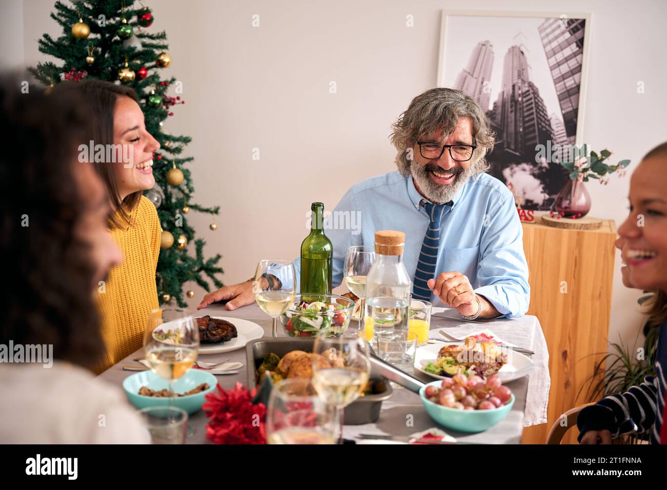 Felice famiglia caucasica multi-generazionale che si diverte a festeggiare il Natale a casa riunita. Foto Stock