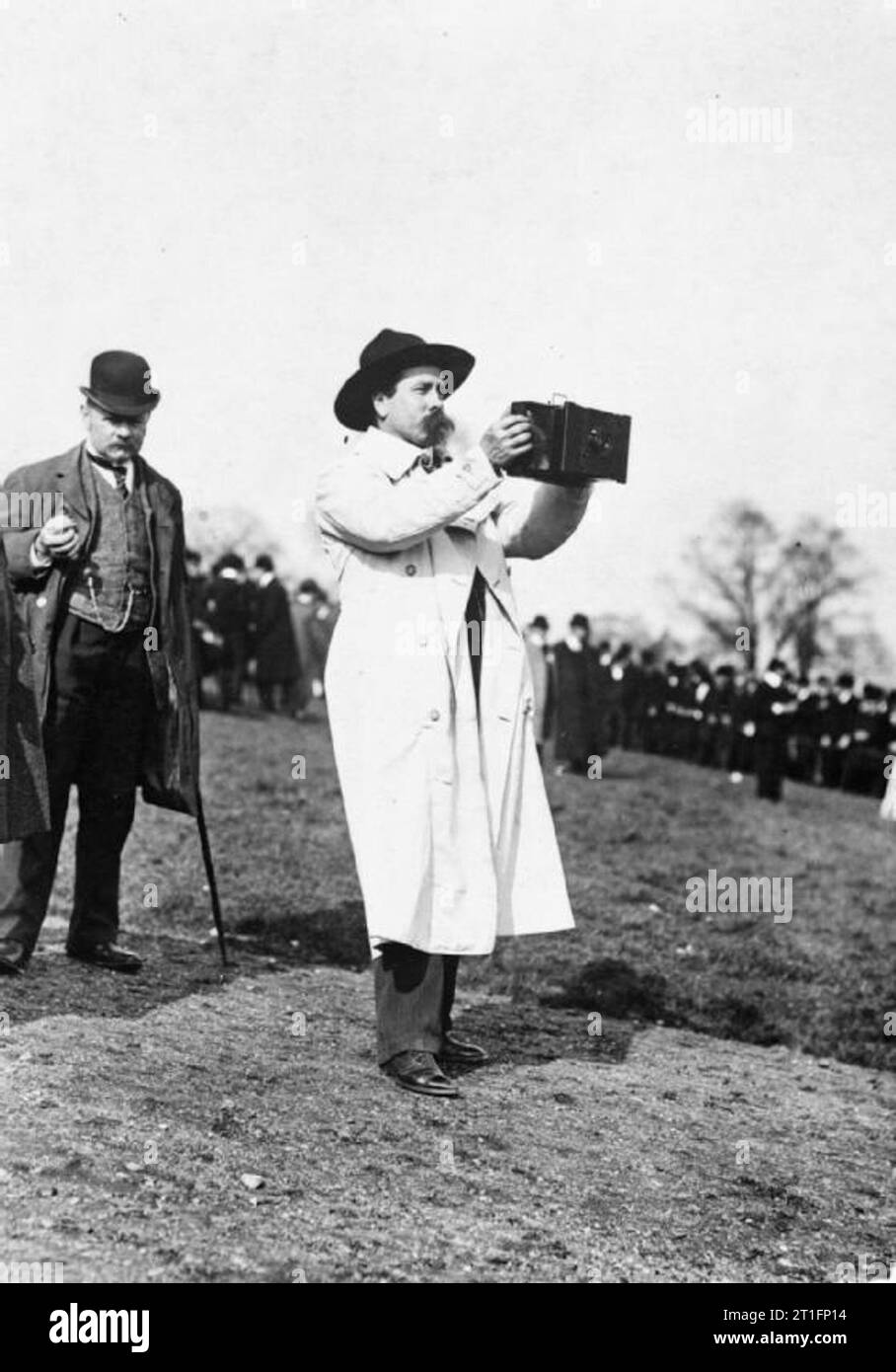 Aviazione in Gran Bretagna prima della Prima Guerra Mondiale a piena lunghezza shot di Cody indossa il suo lungo mantello bianco e il cappello da cowboy si presentò con una telecamera nella motivazione di Alexandra Palace (non visibile). Un gentiluomo di grandi dimensioni in un Bowler cappello si fermò proprio dietro mentre una grande folla può essere visto in background. Fu a Alexandra Palace che egli fece molti concerti del suo Wild West Show e produzioni e aveva botteghe dove ha prodotto gli sfondi per le produzioni come pure la sua aquiloni. Da qui si trasferì al Crystal Palace e infine Laffan chiaro. Foto Stock