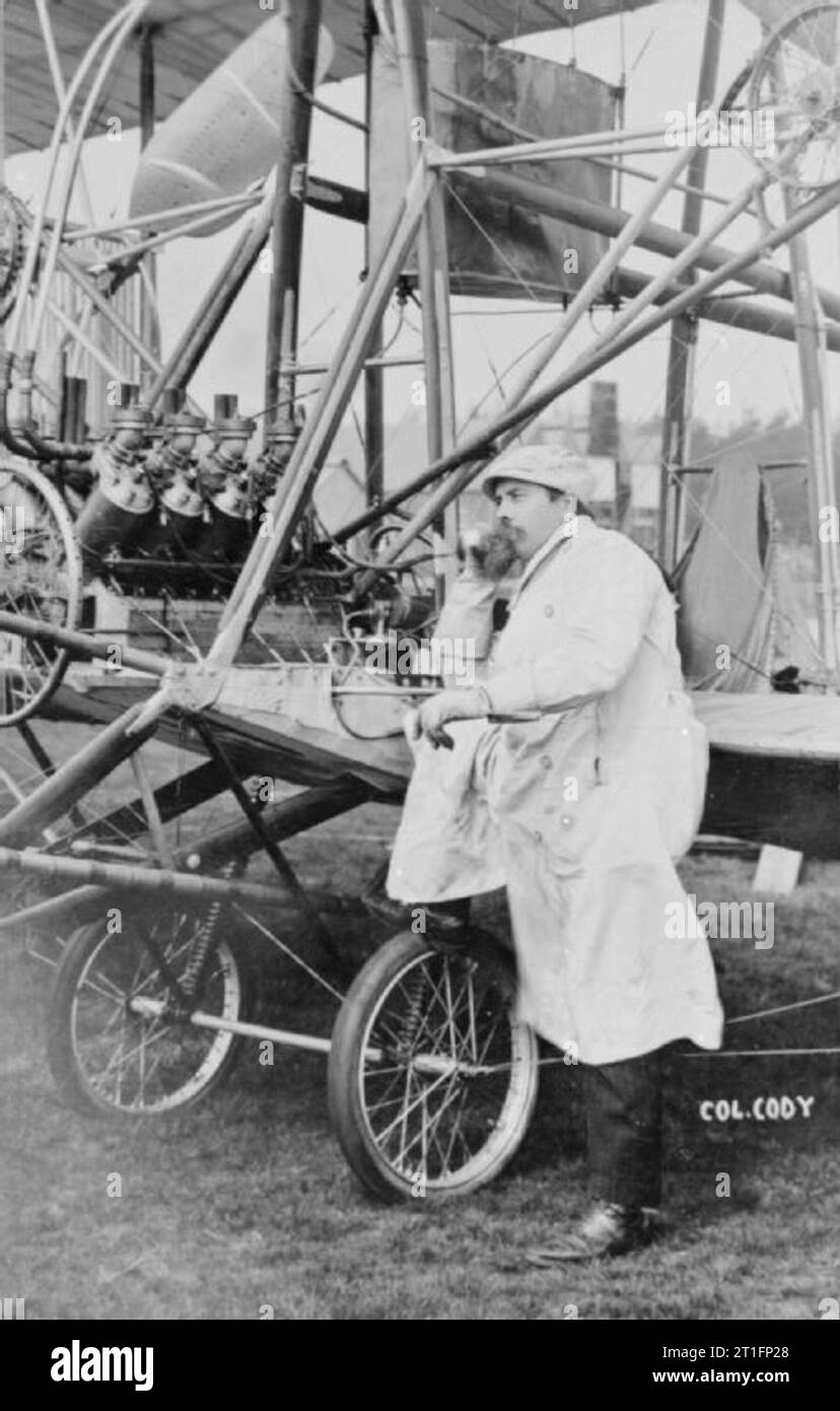 Aviazione in Gran Bretagna prima della prima guerra mondiale un buon vicino di un attenta ricerca Cody indossa il suo lungo mantello bianco e cappuccio in piedi dal cockpit di Cody aeromobile mark IB con il piede sulla ruota del carro e il mento appoggiato sulla sua mano. Questo velivolo è stato ricostruito la versione originale del velivolo in cui Cody ha realizzato il suo primo volo. La differenza principale tra questo e il marchio IA è stata l'aggiunta del biplano coda di sollevamento e spostamento del timone anteriore dietro l'ascensore. In particolare con il suo precedente aeromobile Cody realizzato un costante adeguamento alla disposizione dei battenti Foto Stock