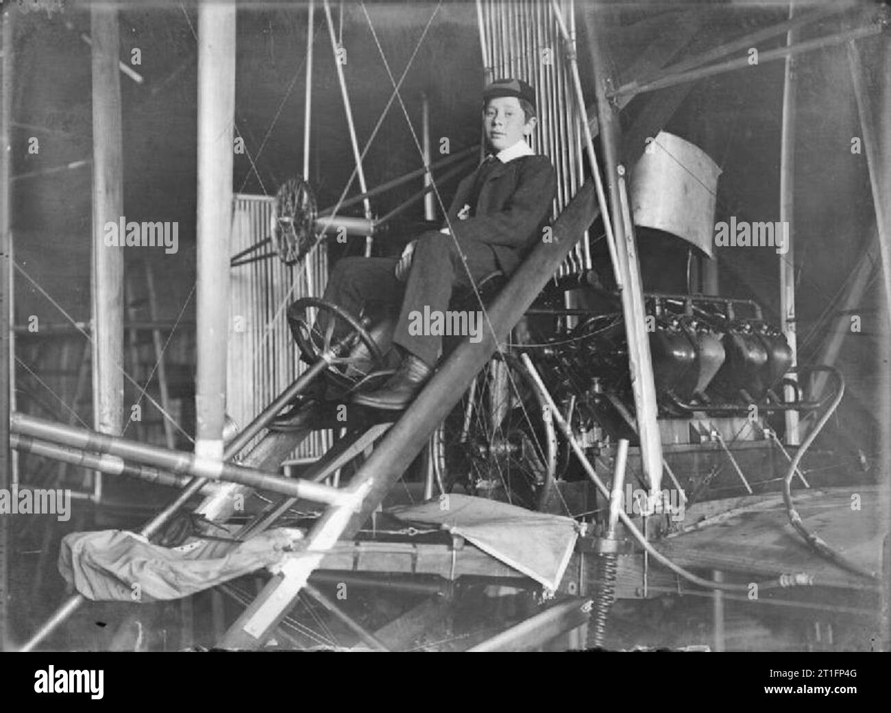 Aviazione in Gran Bretagna prima della prima guerra mondiale Un primo piano di Frank Cody (il figlio più giovane e l'unico figlio naturale di Cody e Lela - vedi sotto per ulteriori dettagli) in uniforme scolastica seduto ai comandi di Cody Aircraft Mark IC (cattedrale - così chiamata a causa delle sue dimensioni e delle dimensioni dell'hangar che richiedeva e la disposizione katahedral (più in basso alle punte delle ali) delle ali) che si trova nel capanno. Il vero nome di LELA Cody era Elizabeth King Nee Davis. Quando lei e Cody si incontrarono (1890 / 1891), si era recentemente separato dalla moglie americana Maud Lee ed era sposata con quattro figli Lizzy, Edward, Foto Stock