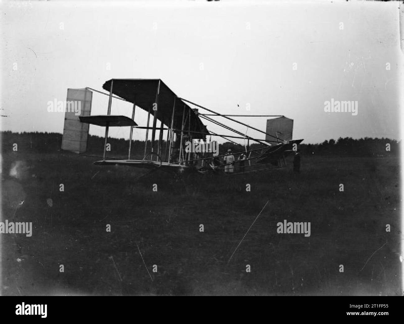 Aviazione in Gran Bretagna prima della prima guerra mondiale Cody Aircraft Mark IC (Cattedrale - così chiamata per le sue dimensioni e le dimensioni dell'hangar che richiedeva e per la disposizione delle ali katahedral (più in basso alle punte delle ali) a terra, l'aereo mostra alcuni segni di danni che potrebbero derivare da un atterraggio troppo pesante (notare la ruota alare allacciata e le aste dell'ascensore piegate). Cody è in piedi sullo sfondo con altri tre uomini. La modifica più importante apportata con questo contrassegno è stata lo spostamento del sedile del pilota nella parte anteriore del motore. L'aereo è stato modificato diverse volte, qui l'alto aggiuntivo Foto Stock