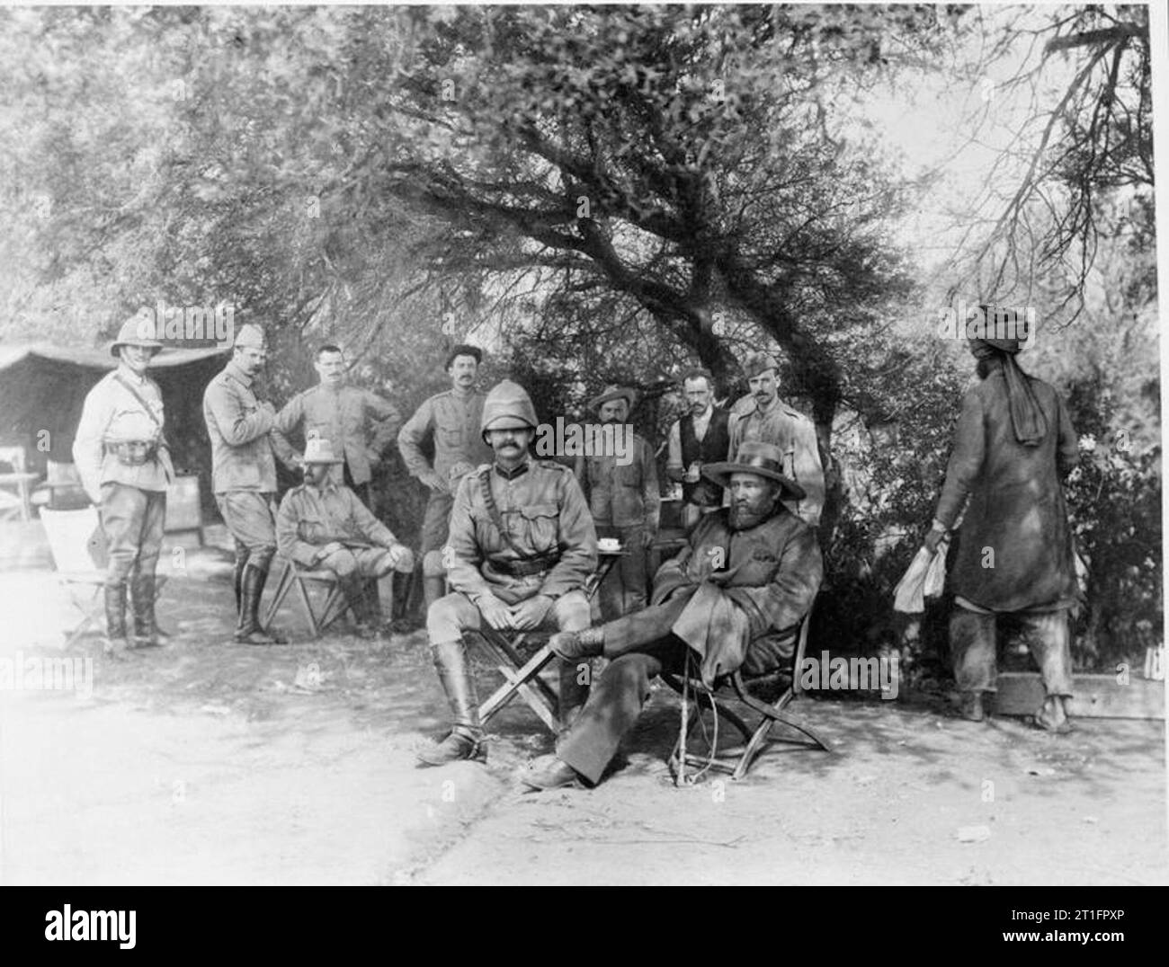 La seconda Anglo - Guerra Boera, Sud Africa 1899 - 1902 General Piet Cronje (in ampia colmato hat) alloggiata nell'ombra con ufficiali britannici dopo la sua rinuncia alla battaglia di Paardeberg. Un indiano servo sta lavorando in background. Foto Stock