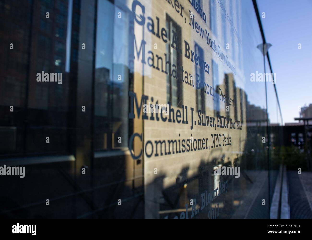 Riflesso astratto di un edificio su una parete di vetro, con il nome dell'edificio visibile nel riflesso Foto Stock