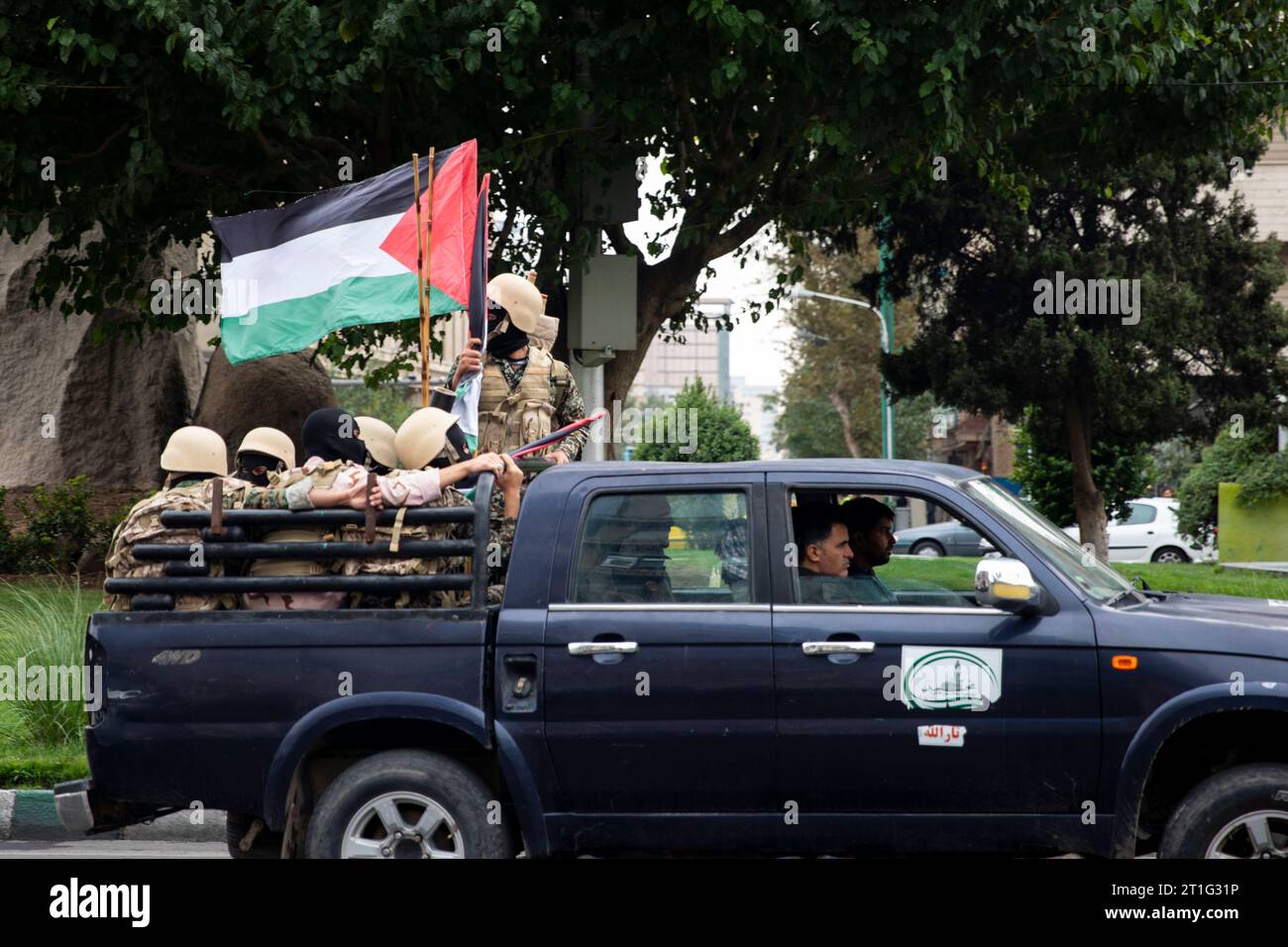 Teheran, Iran. 13 ottobre 2023. I membri della forza paramilitare iraniana Basij, nello stile dei militanti palestinesi e libanesi, detengono una bandiera palestinese durante un raduno pro-palestinese prima delle preghiere del venerdì a Teheran, Iran, venerdì 13 ottobre 2023. (Foto di Sobhan Farajvan/Pacific Press) credito: Pacific Press Media Production Corp./Alamy Live News Foto Stock