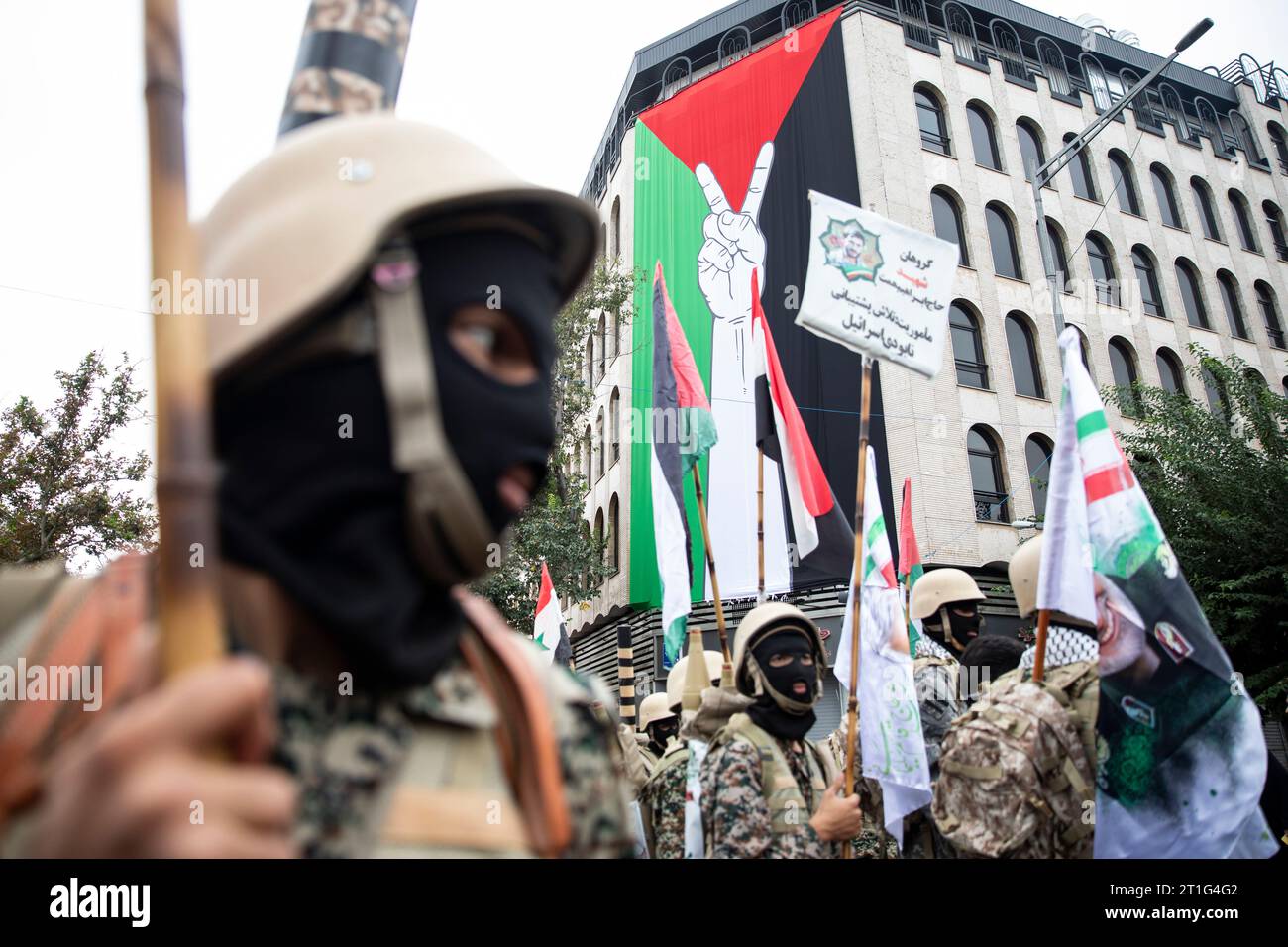 Teheran, Iran. 13 ottobre 2023. Un membro della forza paramilitare iraniana Basij, nello stile dei militanti palestinesi e libanesi, partecipa a una manifestazione pro-palestinese prima della preghiera del venerdì a Teheran, Iran, venerdì 13 ottobre 2023. (Foto di Sobhan Farajvan/Pacific Press) credito: Pacific Press Media Production Corp./Alamy Live News Foto Stock