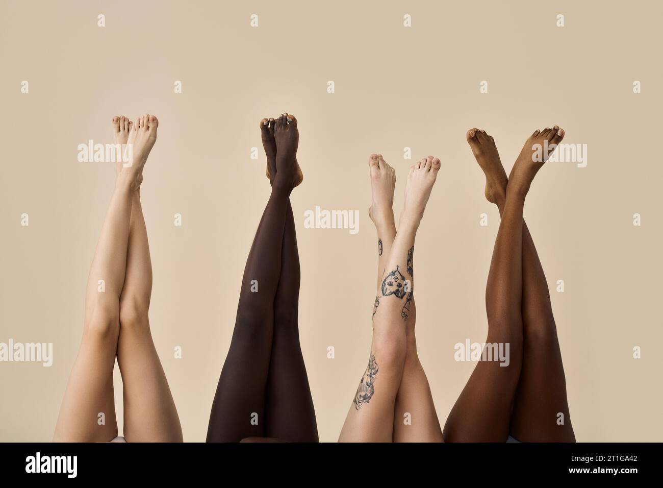 Diverse gambe femminili sollevate su sfondo beige. Sistema di epilazione. Foto Stock