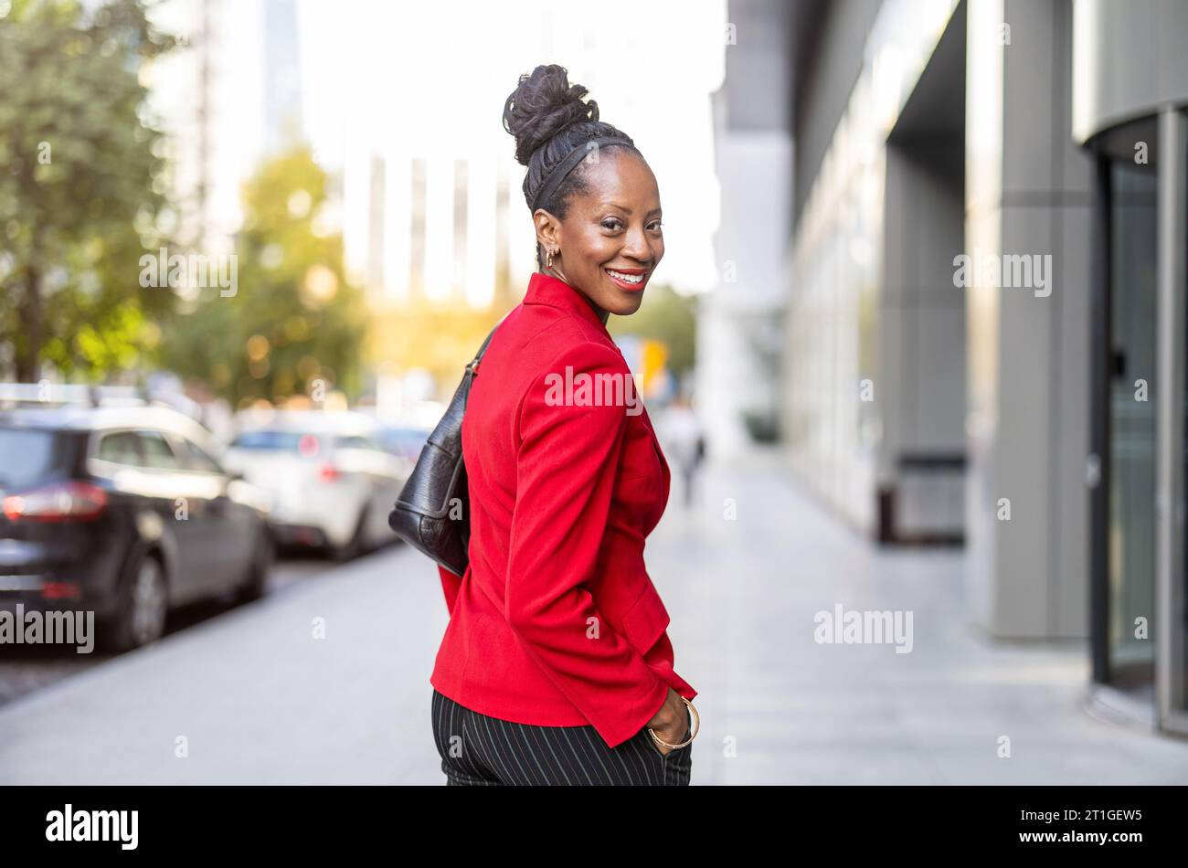 Donna matura sicura di sé che cammina in città Foto Stock