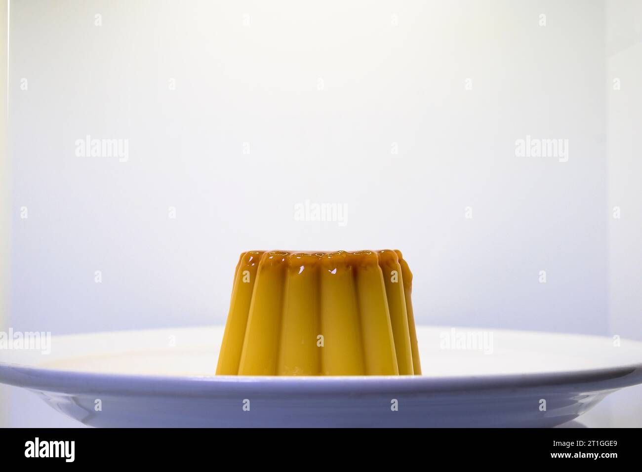 Dessert con crema pasticcera alla vaniglia e uova con caramello con sfondo bianco orizzontalmente Foto Stock