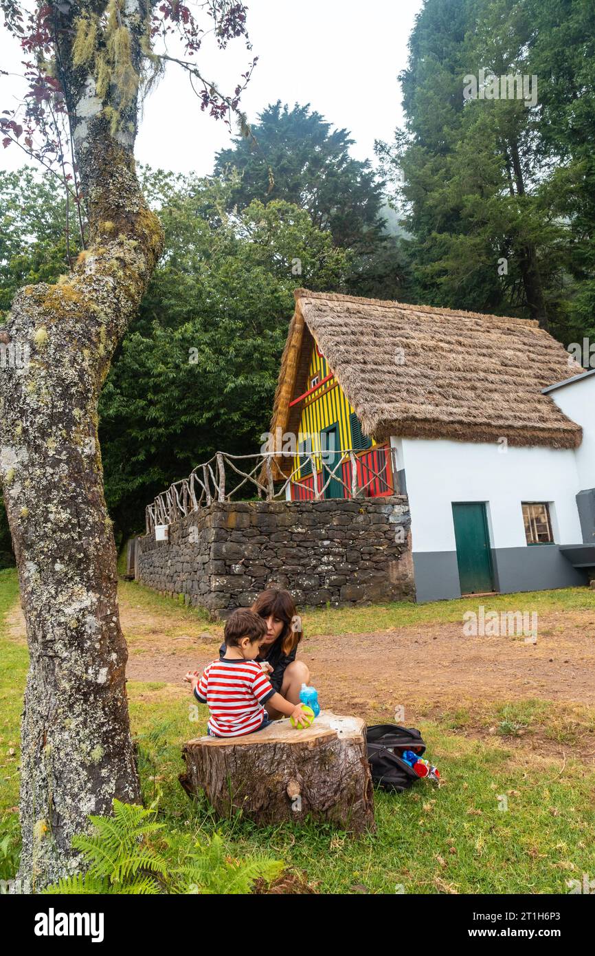 Una famiglia nella tradizionale casa di Madeira come quella di Santana nella foresta di Caldeirao Verde, Santana Foto Stock