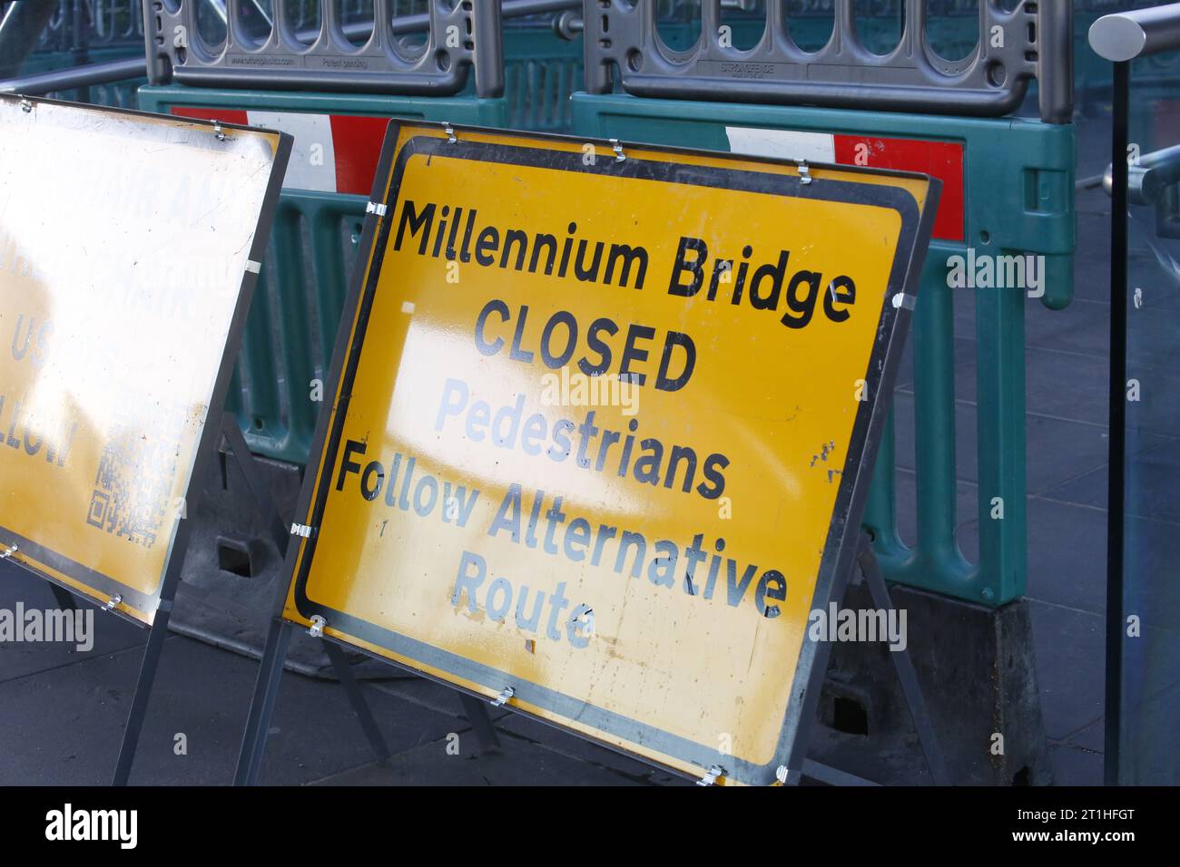 Londra, Regno Unito 14 ottobre 2023 chewing Gum Artist combatte contro il Time to Save Work il Millennium Bridge, il famoso ponte pedonale sul Tamigi, si chiude per restaurare. La chiusura sta causando polemiche in quanto le opere d'arte dipinte sulla gomma da masticare sulla superficie del ponte verranno rimosse. Poco prima della chiusura un rappresentante degli appaltatori che lavorano sul ponte negozia con l'artista, Ben Wilson. Wilson sta lavorando fino all'ultimo minuto per coprire la sua arte in miniatura e proteggerla dalle idropulitrici. Credito: Roland Ravenhill/Alamy. Foto Stock