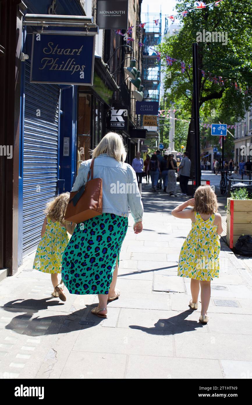 Mamma e le sue due figlie camminano per le strade di Londra, Regno Unito Foto Stock
