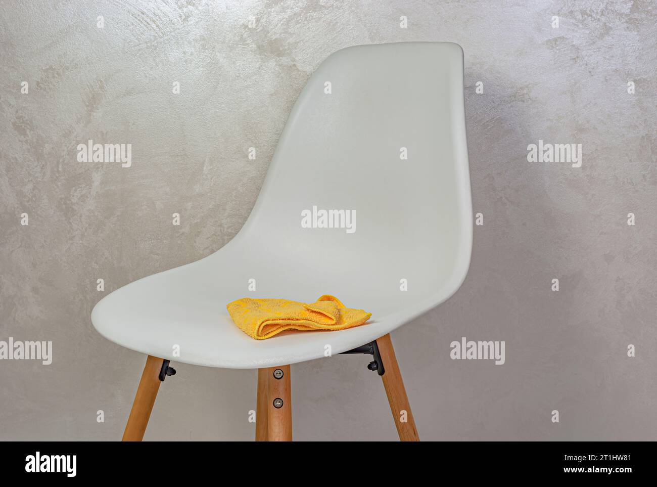 sedia bianca e panno per pulizia giallo Foto Stock