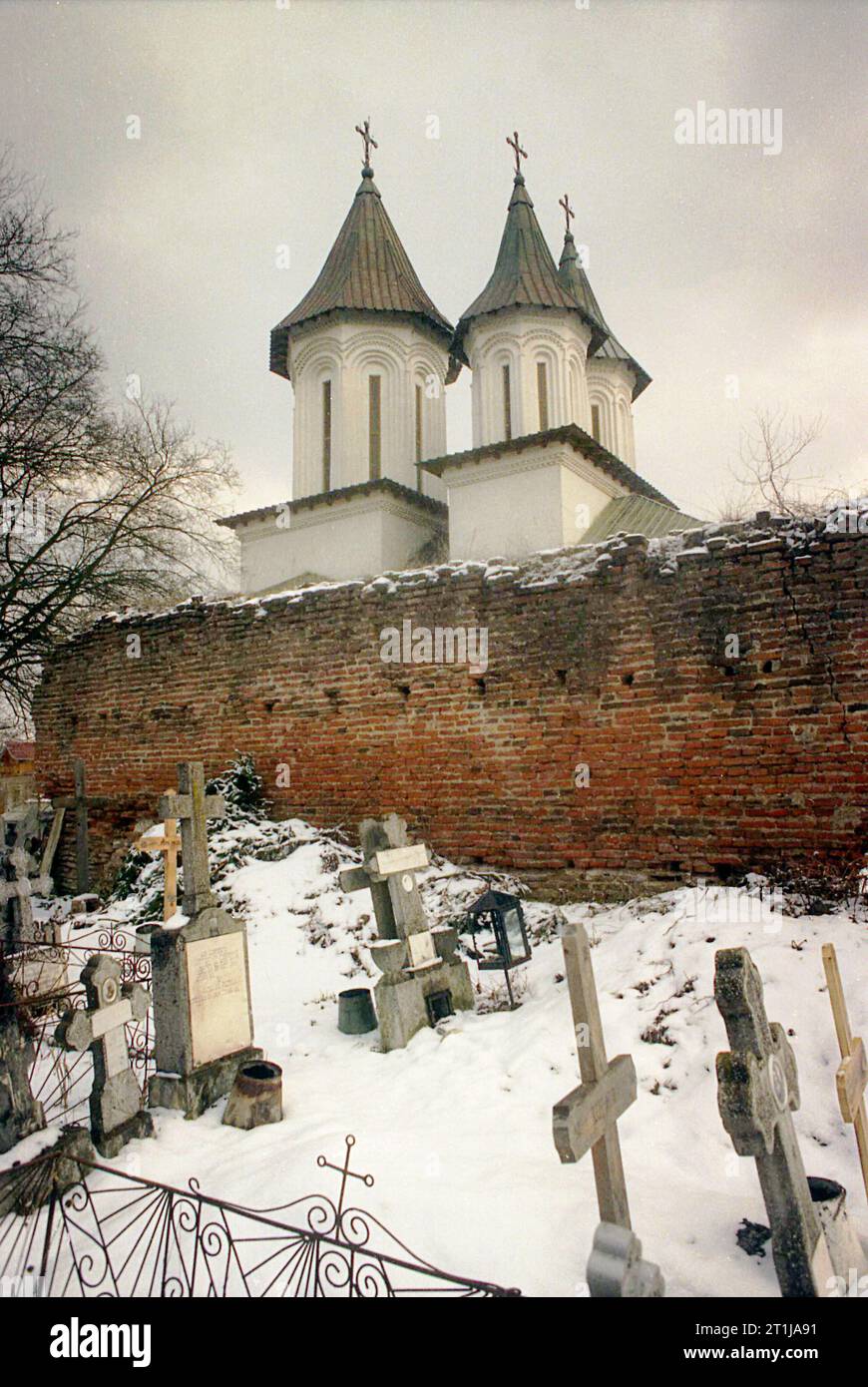 Tutana, Contea di Arges, Romania, 2000. Vista esterna di St La chiesa di Atanasio presso il monastero di Tutana, un monumento storico del XV secolo. Cimitero e rovine delle mura difensive. Foto Stock