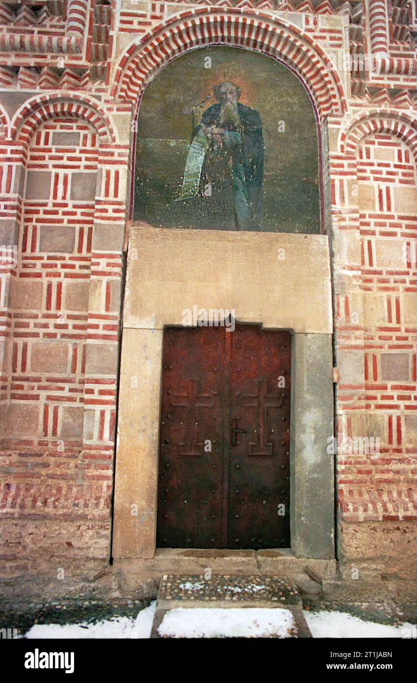 Tutana, Contea di Arges, Romania, 2000. Vista esterna di St La chiesa di Atanasio presso il monastero di Tutana, un monumento storico del XV secolo. Un affresco del santo patrono sopra l'ingresso e l'iscrizione originale scolpita in pietra. Foto Stock