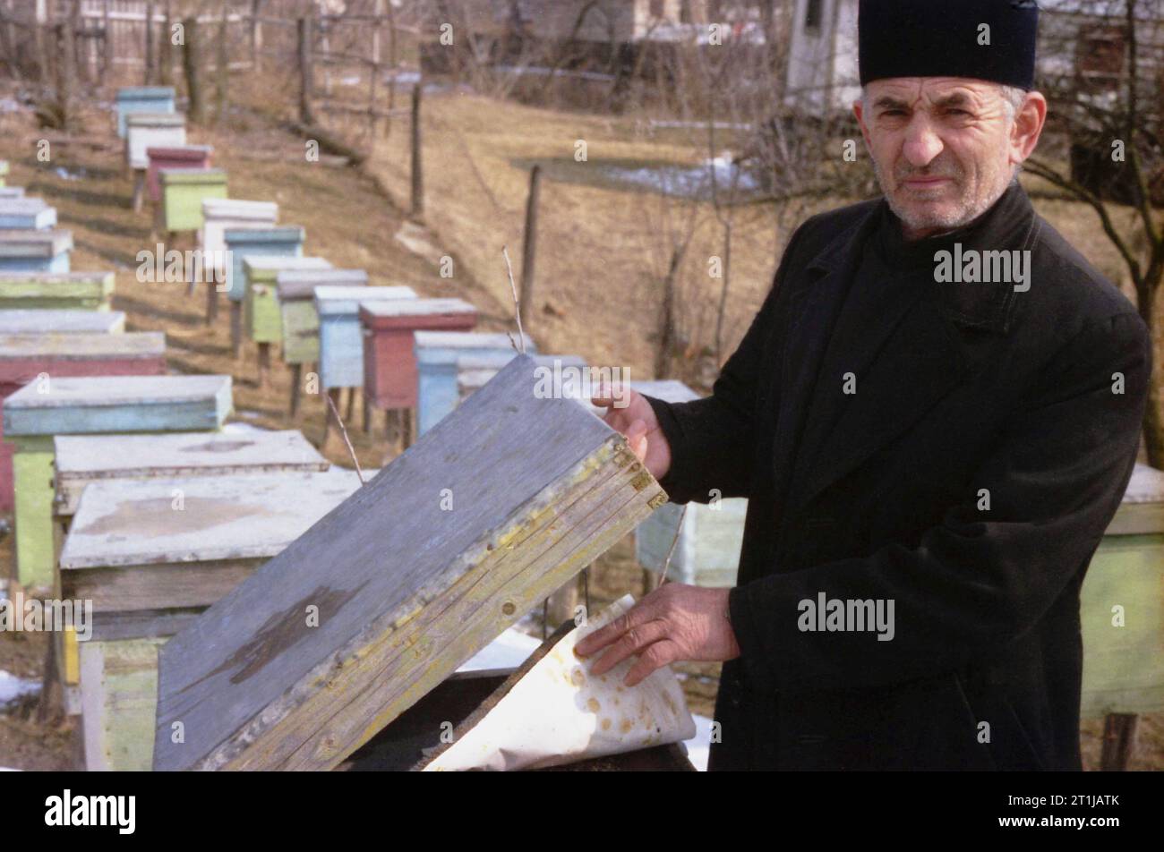 Tutana, Contea di Arges, Romania, 2000. Ritratto di P. Gheorghe Baranescu presso gli alveari nel suo cortile. Foto Stock