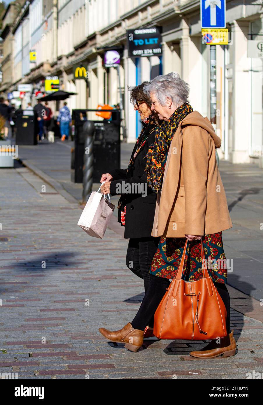 Dundee, Tayside, Scozia, Regno Unito. 14 ottobre 2023. Meteo Regno Unito: In una bella e fredda mattinata autunnale con sole abbagliante, le temperature a Dundee hanno raggiunto i 10°C. Le donne alla moda sono in giro per il centro di Dundee, godendosi il clima soleggiato ma freddo del fine settimana. Crediti: Dundee Photographics/Alamy Live News Foto Stock