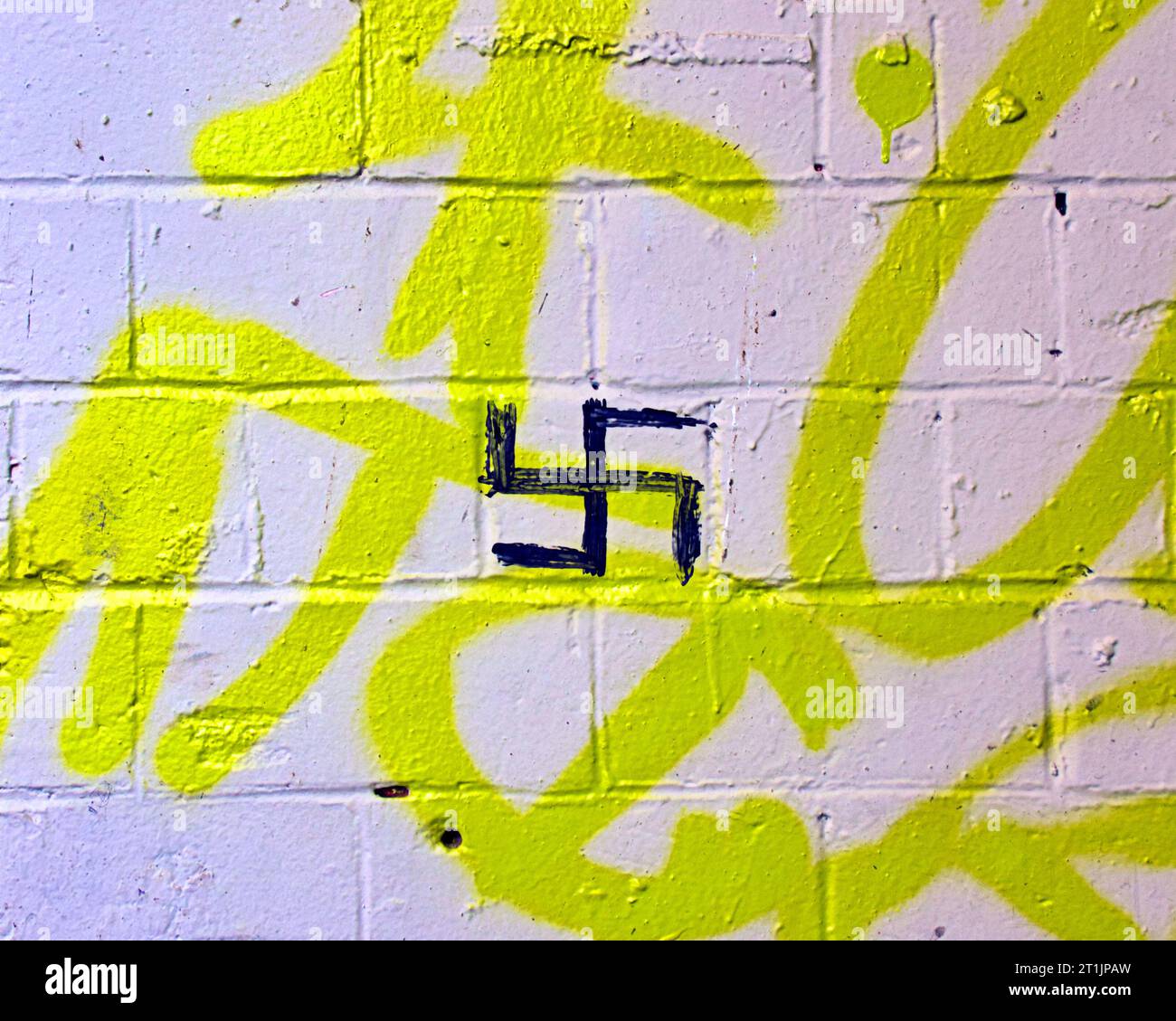 Graffiti del simbolo della svastica nazista raschiati su un muro Foto Stock