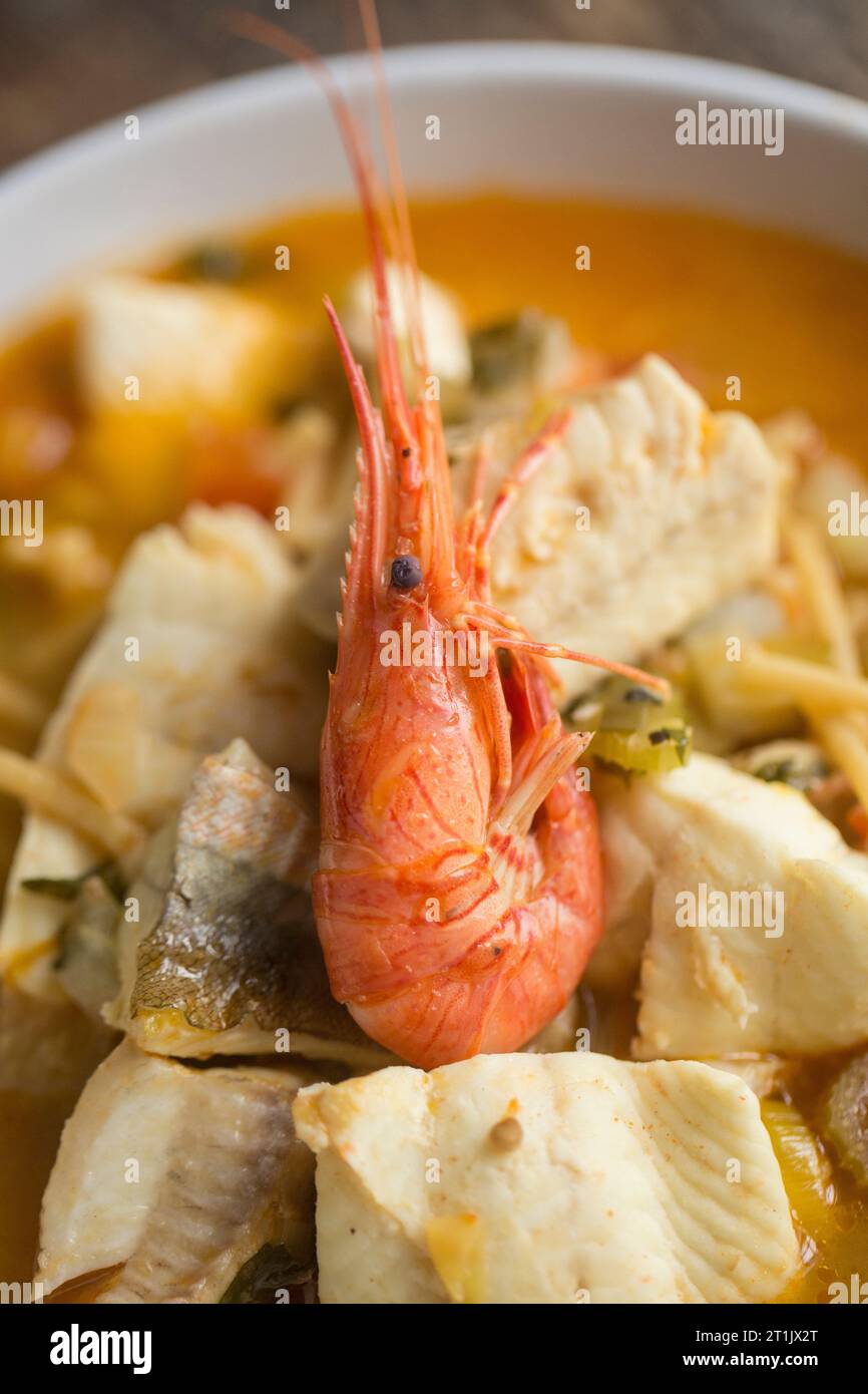 Una zuppa di pesce, aromatizzata allo zafferano, contenente filetti di sogliola di dover, filetti di gurnard e gamberi selvatici catturati. Dorset Inghilterra Regno Unito GB Foto Stock