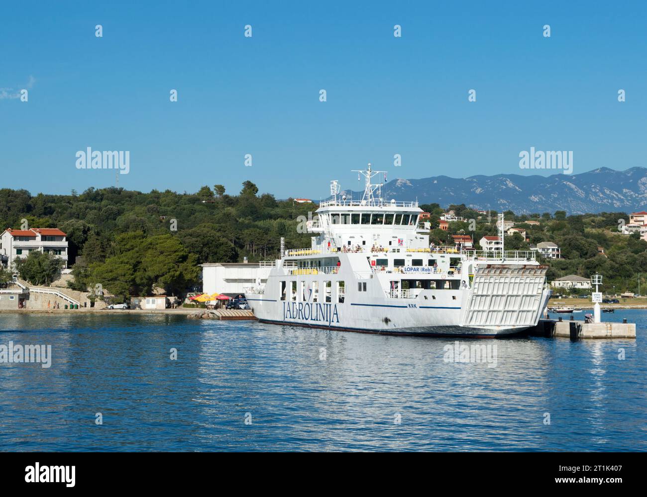 Lopar, Croazia - luglio 2020: Traghetto passeggeri e auto al molo di Lopar sulle isole Rab, di proprietà di Jadrolinija, compagnia di navigazione croata Foto Stock