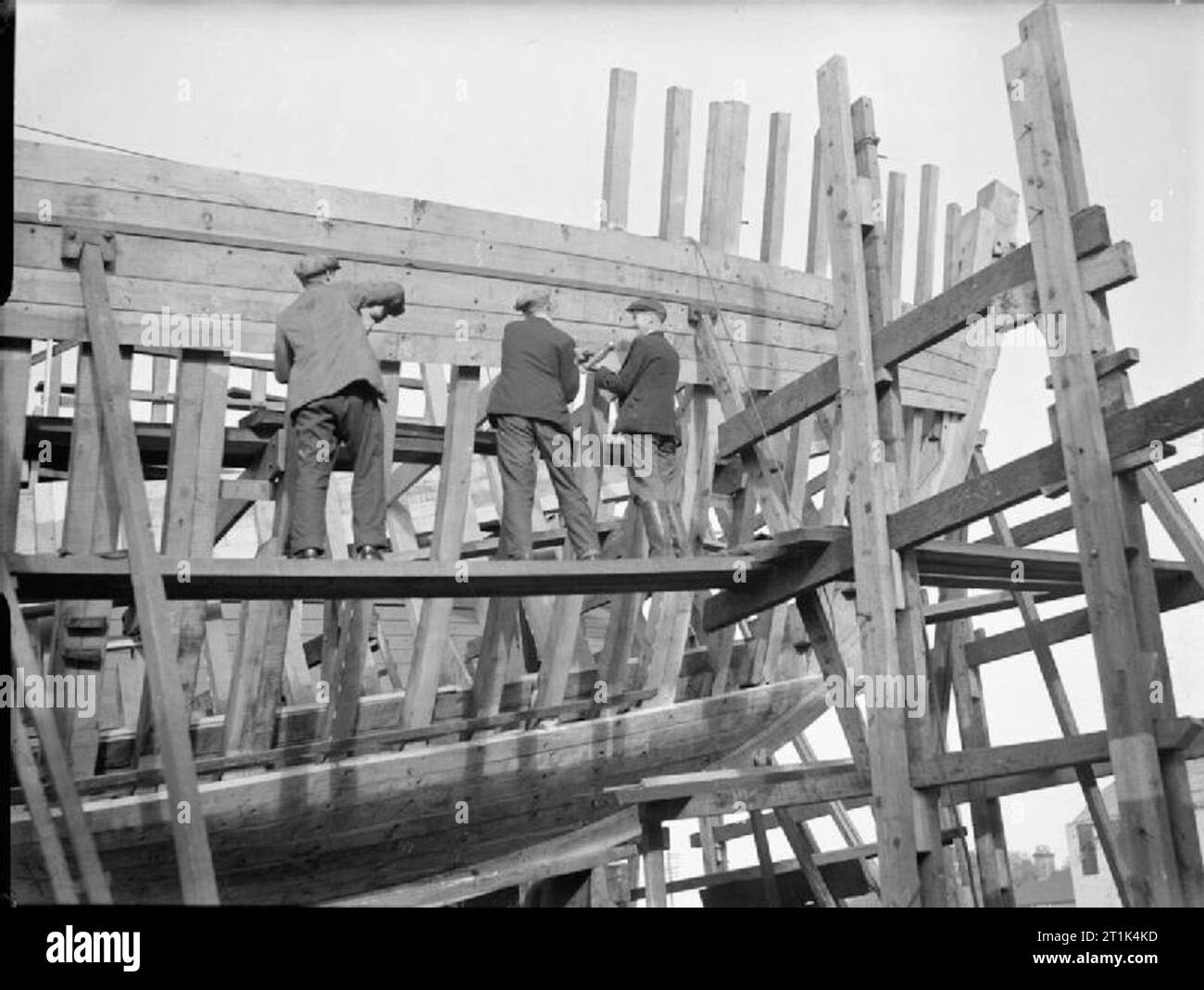 Il settore della costruzione navale in Gran Bretagna durante la Seconda Guerra Mondiale tre costruttori navali a lavorare alla costruzione di un dragamine presso un cantiere navale sulla costa orientale dell'Inghilterra. Foto Stock