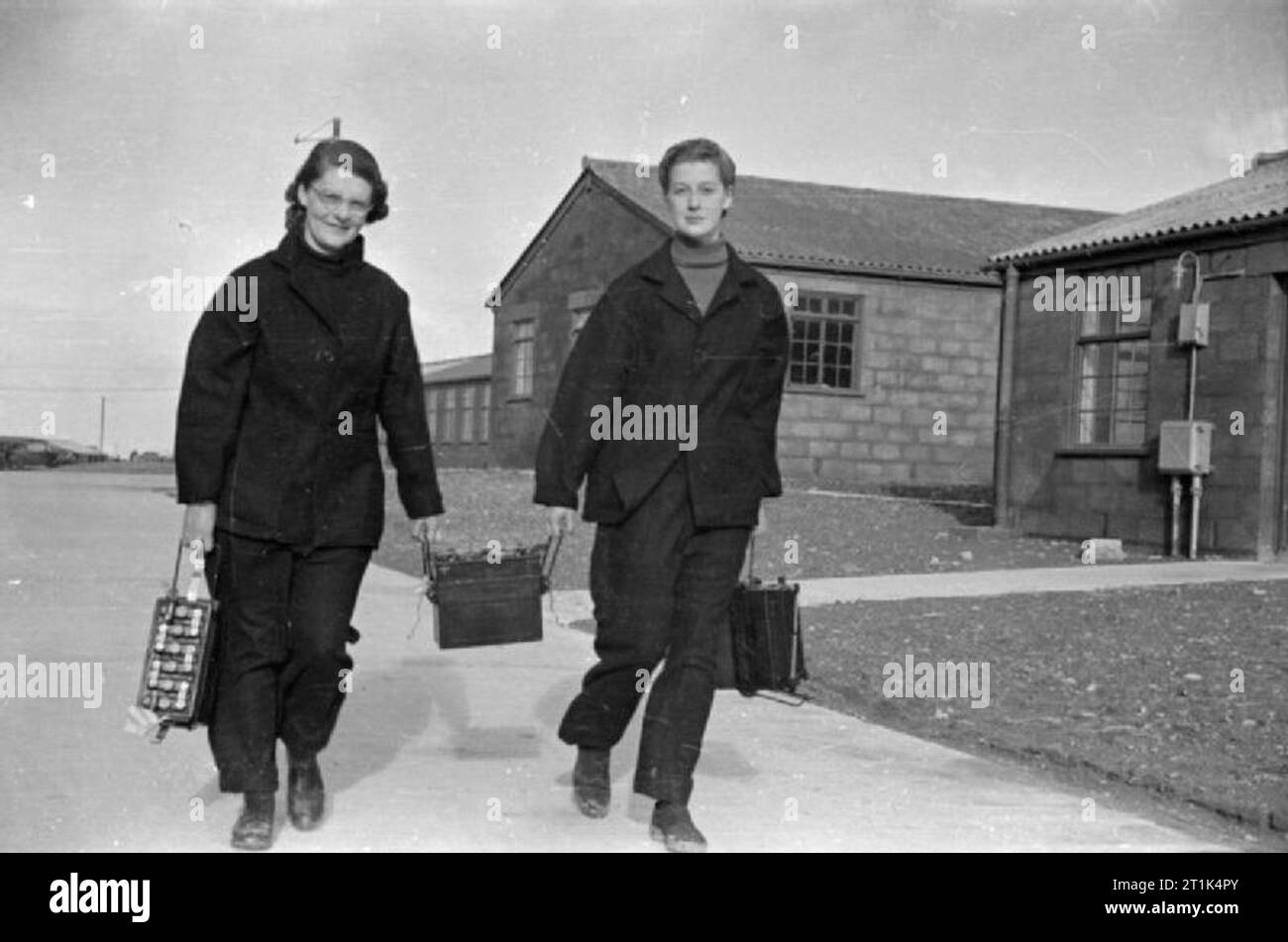 Le donne del Royal Naval servizio durante la Seconda Guerra Mondiale Wrens portando batterie torna alla camera dell'accumulatore per la ricarica di un Fleet Air Arm stazione. Foto Stock