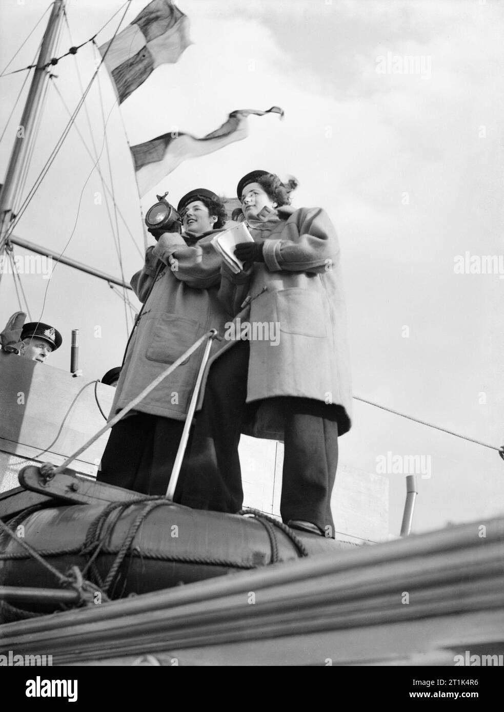 Le donne del Royal Naval servizio durante la Seconda Guerra Mondiale due Wren signalwomen, completo di campana pantaloni di fondo, al lavoro a bordo di una Royal Navy ship per esperienza di segnale al largo della costa di Greenock, Scozia. Foto Stock