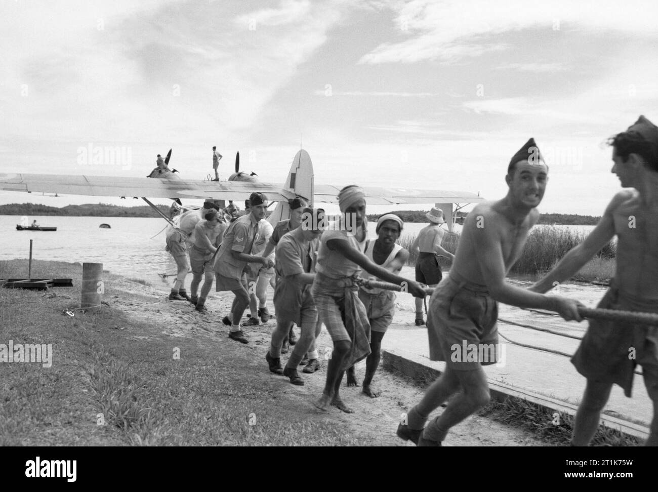 RAF Groundcrew e locale Singhalese abbassando una Catalina consolidata di No. 240 Squadron RAF nell'acqua a Red Hills Lake, Ceylon, dopo lavori di riparazione, il 4 agosto 1945. Foto Stock