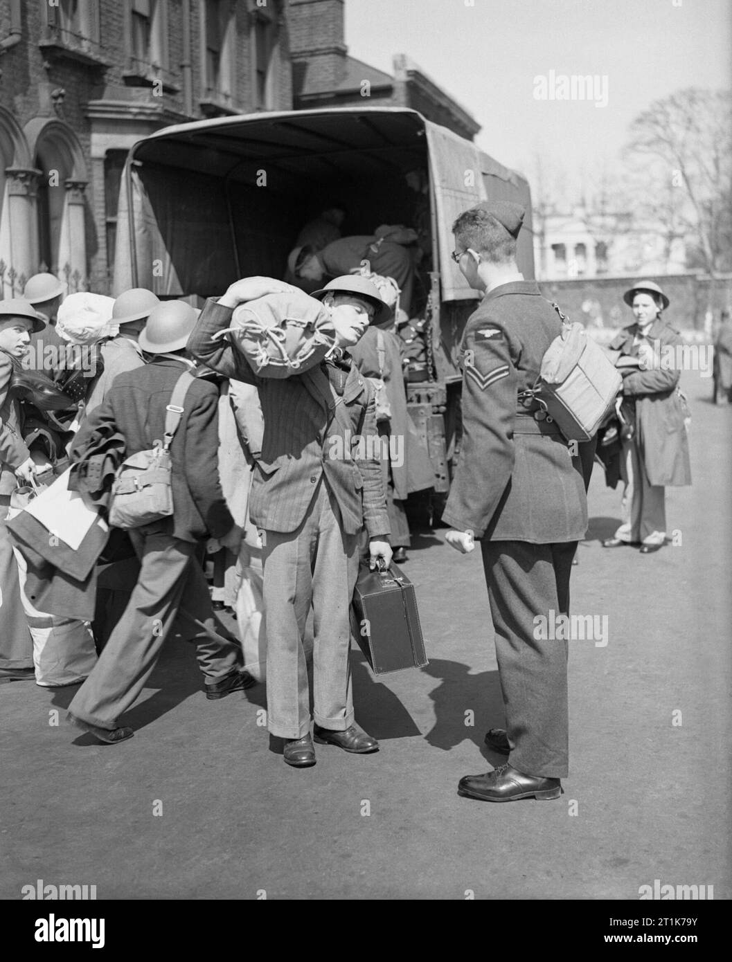 RAF reclute raccogliere i loro sacchi di kit da un autocarro presso la RAF equipaggio a Centro di accoglienza, Regent's Park, Londra, 27 aprile 1942. Phillip Fricker e altre reclute raccogliere i loro sacchi di kit da un autocarro presso la Royal Air Force equipaggio a Centro di accoglienza, Regent's Park, Londra. Foto Stock