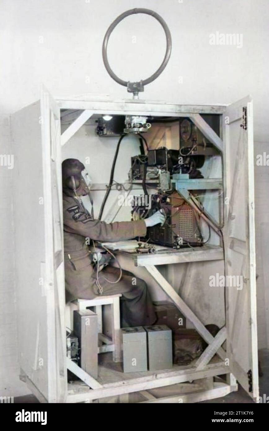 . Royal Air Force, 1939-1941. Un opérateur radio-navigant en formation sur un ensemble d'émetteur/récepteur T1083/R1082, étant assis dans une maquette en bois. Unité de formation opérationnelle, Abingdon, Berkshire. Son ensemble est connecté à une radiogoniométrie constituée d'une antenne en boucle au-dessus du compartimentRoyal Air Force Bomber Command, 1939-1941. Un operatore wireless utilizza il proprio set trasmettitore/ricevitore T1083/R1082, seduto in un modello di legno della posizione di un operatore wireless in un Armstrong Whitworth Whitley, presso la No. 10 Operational Training Unit, Abingdon, Berkshire. Il suo set i Foto Stock