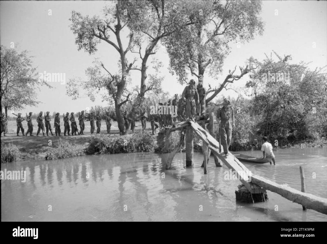 Royal Air Force operazioni in Estremo Oriente, 1941-1945 un reggimento di RAF patrol attraversa uno stretto ponte su un fiume, mentre è in corso la ricerca di dacoits nella regione di Kaladan della Birmania. Questi gli avieri facevano parte di una Task Force, disegnato da n. 1326 Ala reggimento RAF e comandati da Ala Commande G Gow, che ristabilita amministrazione britannica nella regione dopo la sua liberazione. Foto Stock