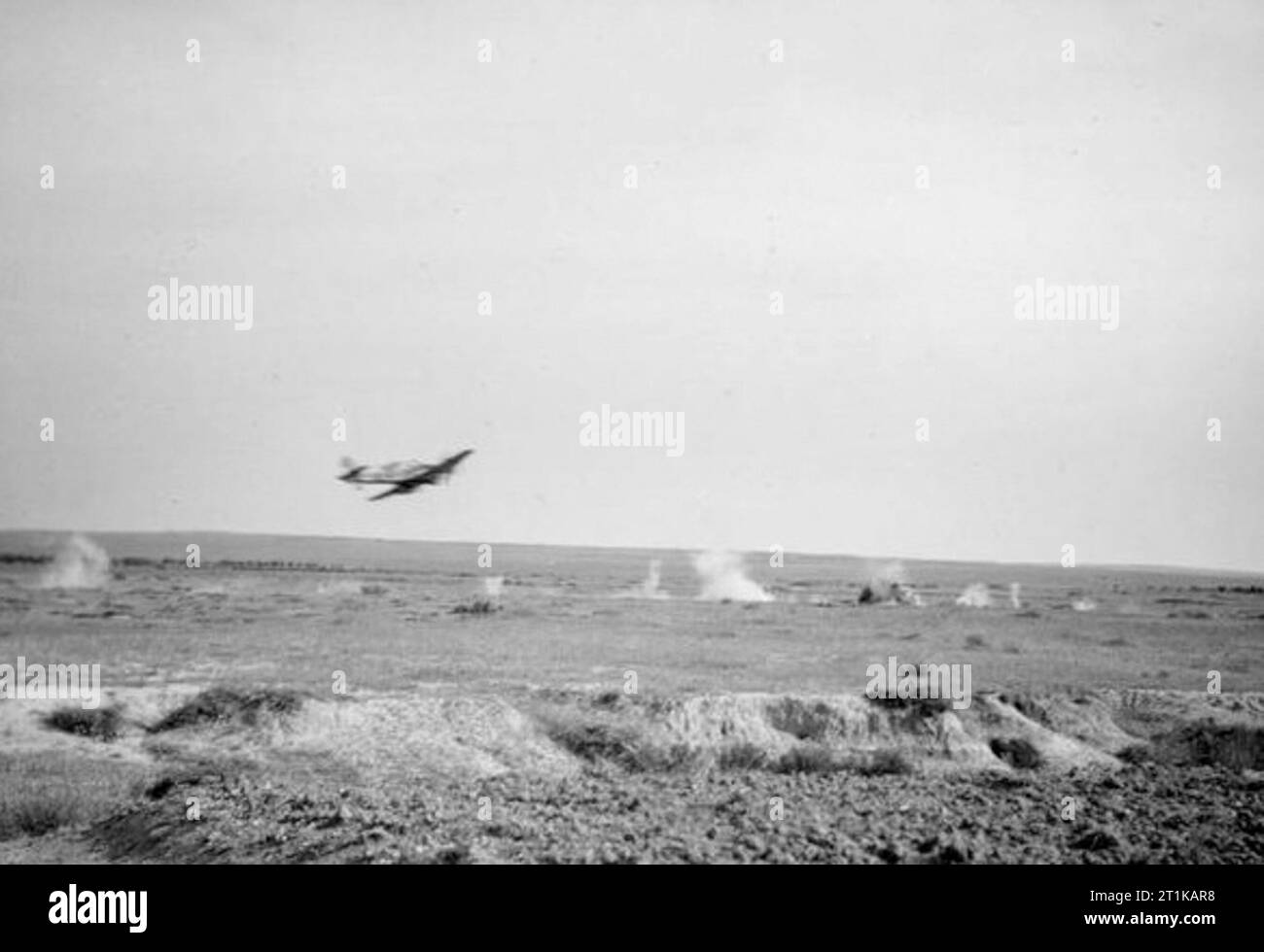 Royal Air Force operazioni in Medio Oriente e Nord Africa, 1939-1943. Un Hawker Hurricane Mark IID di n. 6 Squadron RAF dà una dimostrazione della potenza di fuoco della sua Vickers 40mm tipo S cannoni anticarro contro i derelitti carri armati tedeschi nel nord deserto africano. Foto Stock