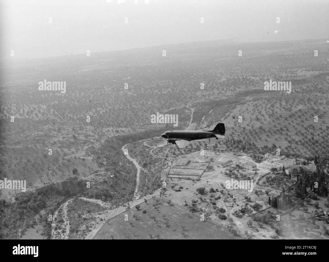 Royal Air Force - L'Italia, i paesi dei Balcani e del sud-est Europa, 1942-1945. Un Douglas Dakota di n. 216 Gruppo RAF, volare al di sopra degli aranceti e terreni agricoli in Puglia, Italia, mentre la consegna delle forniture a RAF ali in corrispondenza di Grottaglie. Foto Stock