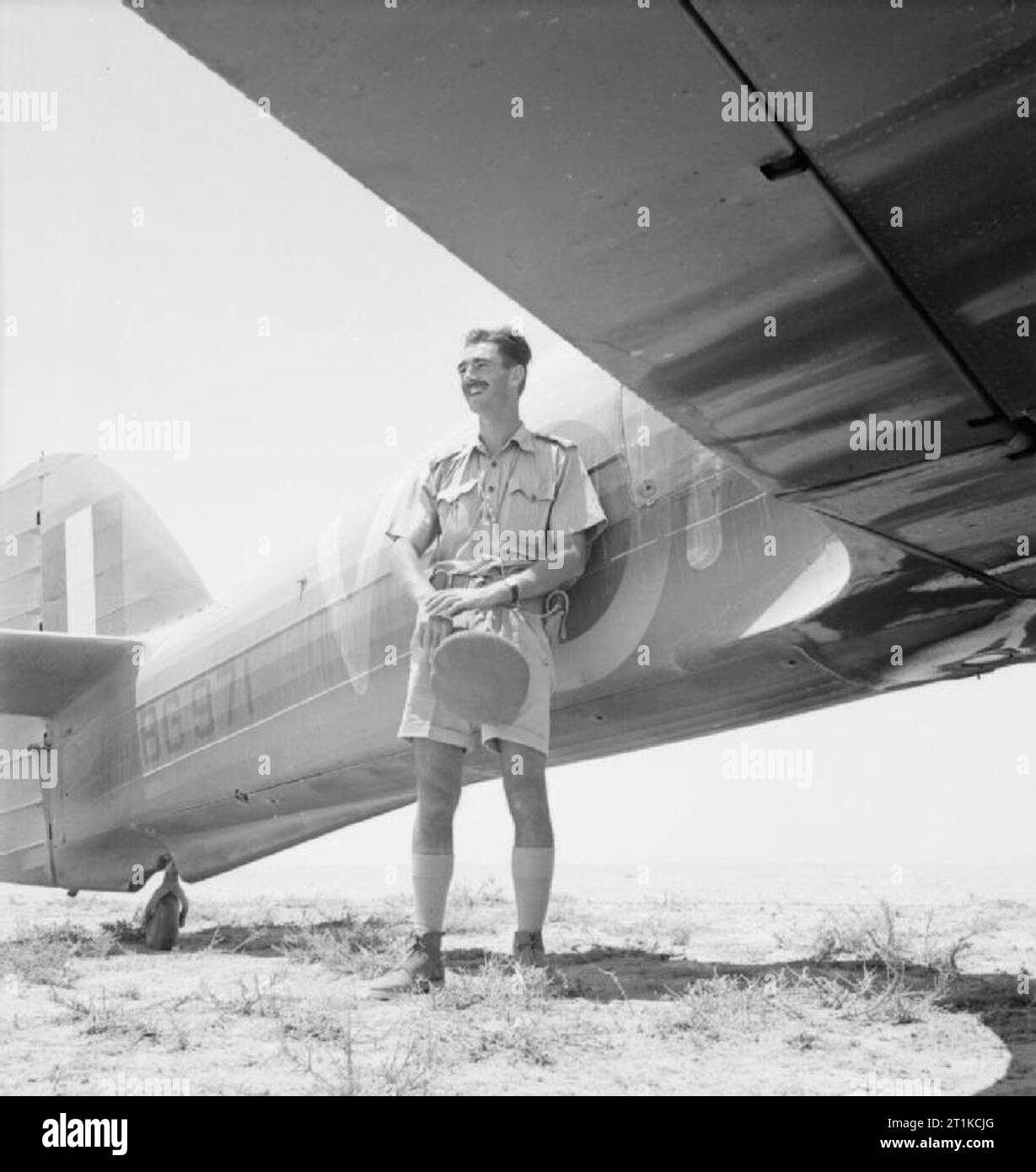 Royal Air Force- Operazioni in Medio Oriente e Nord Africa, 1939-1943. Maggiori G J 'Lemmie' le Mesurier, comandante n. 1 Squadron SAAF, in piedi dal suo Hawker Hurricane Mark IIB, BG971 'AX-V', a LG 92, Egitto. Il 3 luglio 1942 le Mesurier, battenti BG971, led undici uragani ad intercettare una dive-bombardamento in El Alamein area. Mentre il velivolo di n. 274 Squadrone RAF previsto coperchio superiore il sudafricano uragani hanno attaccato una grande formazione di Junkers Ju 87Bs e riuscito a tiro giù tredici in quello che sarebbe diventato noto come la Alamein 'Stuka parte". Il giorno seguente, le Foto Stock