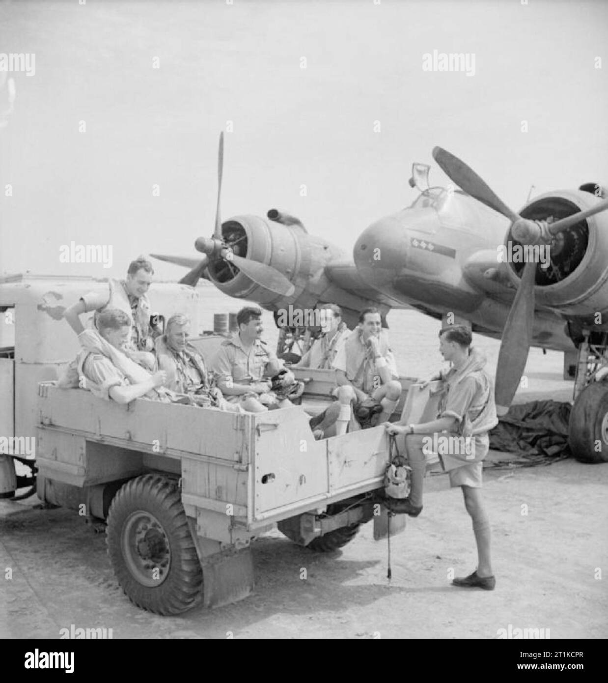 Royal Air Force- Operazioni in Medio Oriente e Nord Africa, 1940-1943. Equipaggio di n. 252 Squadrone RAF salire nel retro di un camion per l'unità per il loro quartier generale a Idku, Egitto, dopo un colpo di successo su un nemico treno di alimentazione che trasportano armi da fuoco e le munizioni nei pressi di Bir Abu Mischeifa. Quattro Bristol Beaufighters dello squadrone scortato tre Bristol Bisleys di n. 15 Squadron SAAF al bersaglio, che è stata completamente distrutta. In mezzo al gruppo siede Wing Commander P H Bragg, comandante dello Squadrone 252, che ha guidato l'attacco, e seduta terzo da sinistra è uno dei suoi f Foto Stock