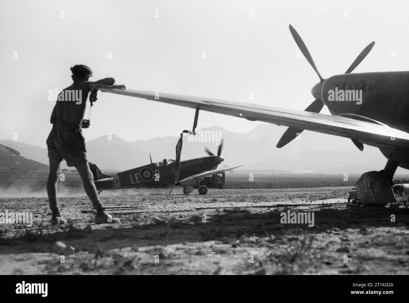 Il Supermarine Spitfire Mark IXs di n. 242 Squadrone RAF a Calenzana, Corsica, dopo una pattuglia sull'invasione spiagge nel sud della Francia, 17 agosto 1944. Operazione Dragoon: l'invasione alleata della Francia meridionale. Un Supermarine Spitfire Mark IX di n. 242 Squadrone RAF taxi passato un altro aeromobile parcheggiata per un punto di rifornimento a Calenzana, Corsica, dopo una pattuglia di copertura sull'invasione spiagge. Foto Stock