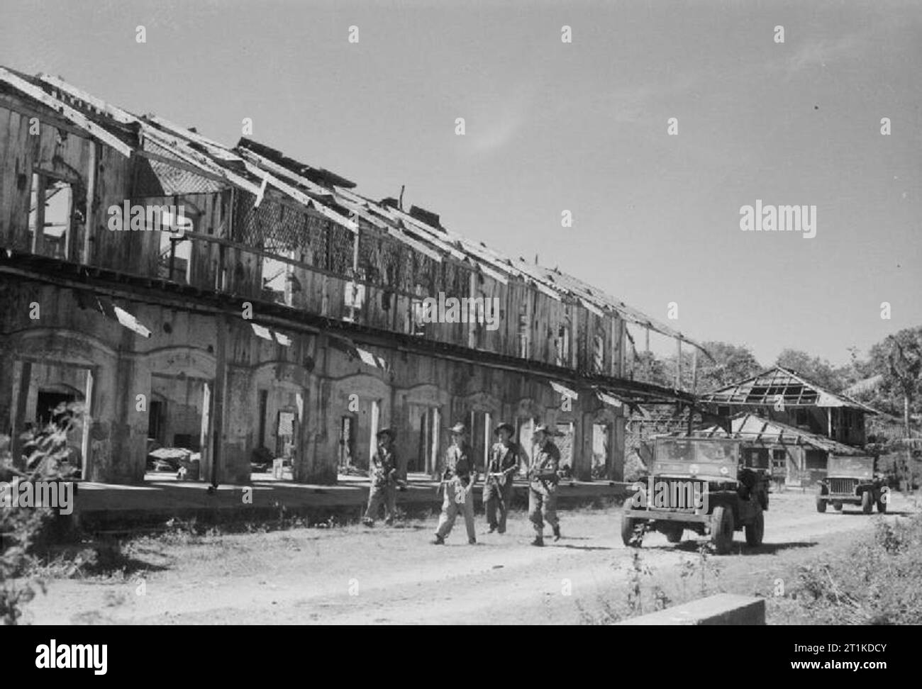 La guerra in Estremo Oriente- la Birmania campagna 1941-1945 la campagna di Arakan Gennaio 1943 - Maggio 1945: gli uomini della Royal Air Force anticipo assault party pass una bomba ha danneggiato edificio dopo gli sbarchi su Ramree Island. Foto Stock