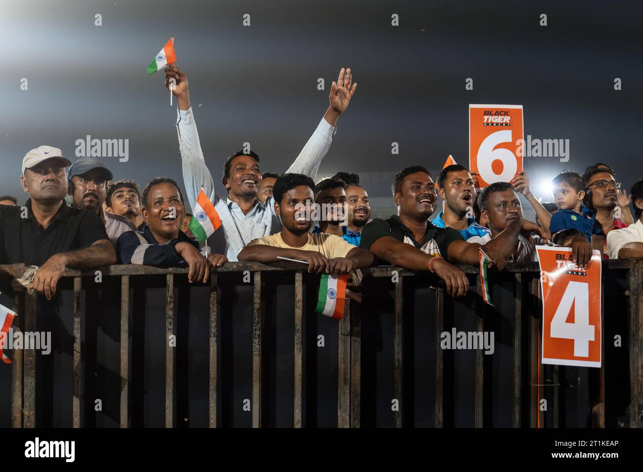 I tifosi indiani di cricket applaudono mentre guardano la partita internazionale di un giorno della Coppa del mondo di cricket maschile 2023 (ODI) tra India e Pakistan sullo schermo di un proiettore in un campo, il 14 ottobre 2023 a Guwahati, Assam, India. L'India ha sconfitto il Pakistan con 7 wicket. Credito: David Talukdar/Alamy Live News Foto Stock