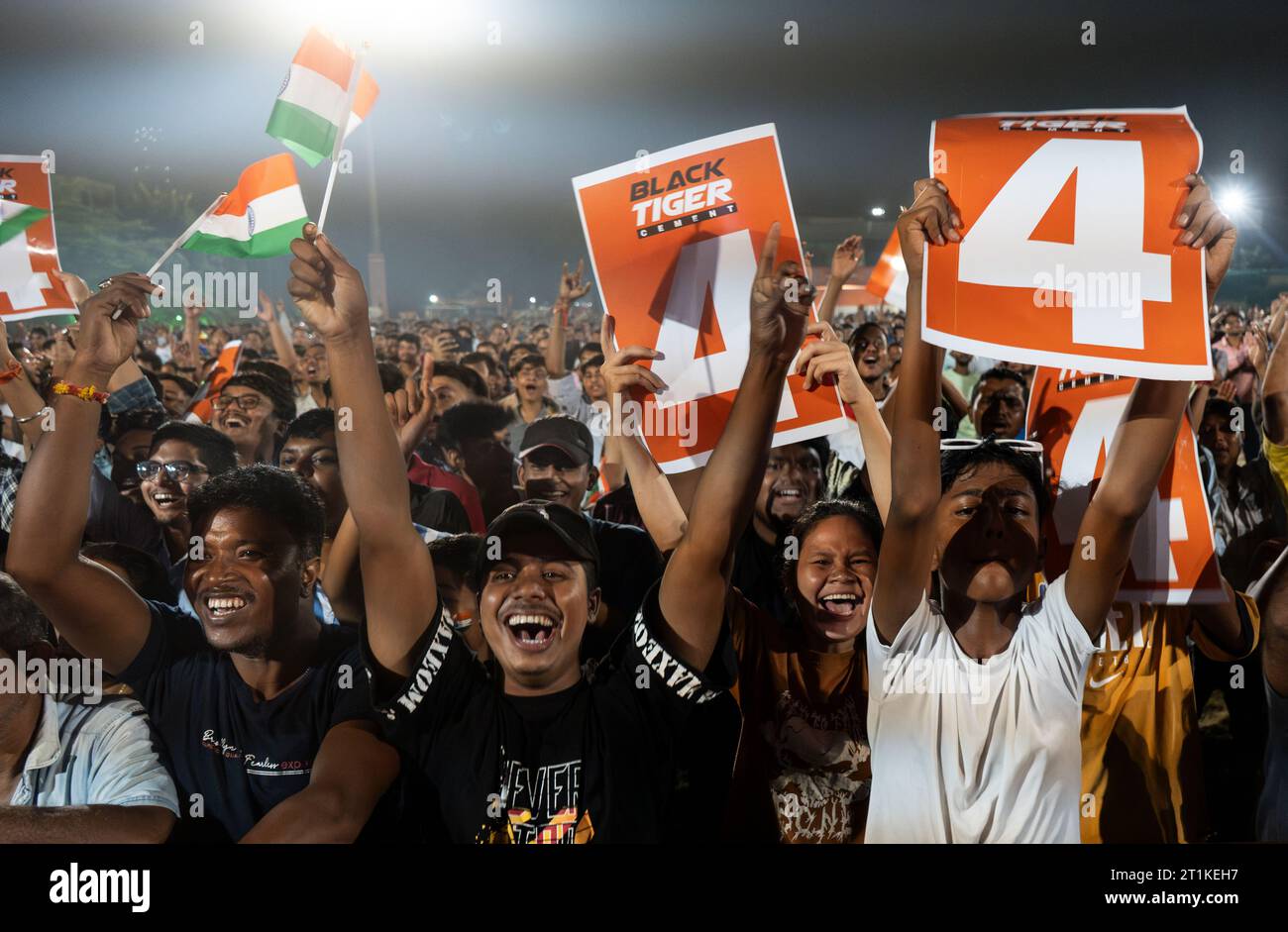 I tifosi indiani di cricket applaudono mentre guardano la partita internazionale di un giorno della Coppa del mondo di cricket maschile 2023 (ODI) tra India e Pakistan sullo schermo di un proiettore in un campo, il 14 ottobre 2023 a Guwahati, Assam, India. L'India ha sconfitto il Pakistan con 7 wicket. Credito: David Talukdar/Alamy Live News Foto Stock