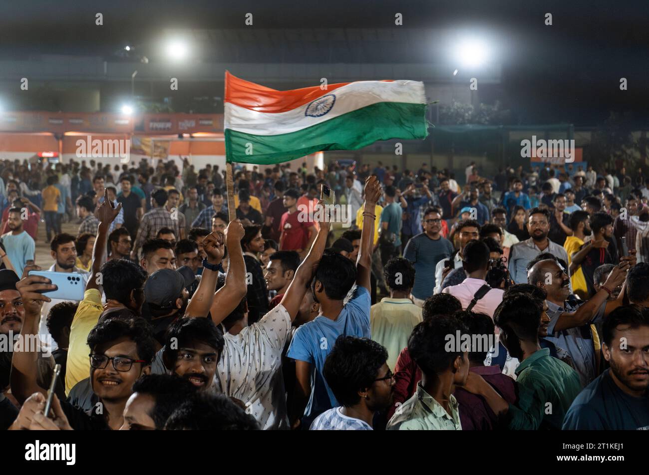 I tifosi indiani di cricket applaudono mentre guardano la partita internazionale di un giorno della Coppa del mondo di cricket maschile 2023 (ODI) tra India e Pakistan sullo schermo di un proiettore in un campo, il 14 ottobre 2023 a Guwahati, Assam, India. L'India ha sconfitto il Pakistan con 7 wicket. Credito: David Talukdar/Alamy Live News Foto Stock