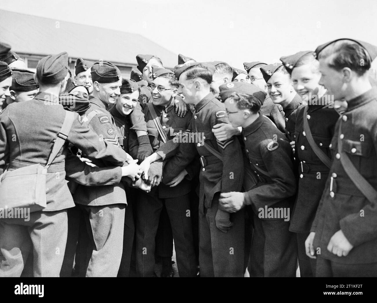 Compagno di allenamento di aria Corps cadetti dare Phillip Fricker un entusiasta send off come egli lascia per unire la RAF, Dartford Kent, aprile 1942. Phillip Fricker, una ventina di anni sergente di volo nella formazione dell'aria Corps (ATC) lascia per entrare a far parte della Royal Air Force. I cadetti del suo squadrone locale in Dartford Kent, dargli un entusiasta send-off. Foto Stock