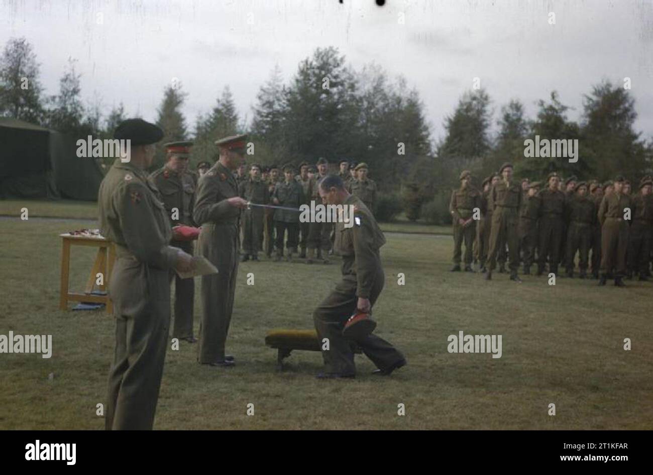 Hm King George VI con il British Liberation Army in Olanda, 15 ottobre 1944 il Comandante di corpo 1, Tenente Generale J T Crocker è realizzato un Cavaliere Comandante dell'impero britannico da HM King George VI durante un'investitura tenutasi presso il quartier generale del comandante del xxi gruppo dell'esercito, il Maresciallo di Campo Sir Bernard Montgomery. Maresciallo di Campo Montgomery è in piedi in primo piano. Foto Stock